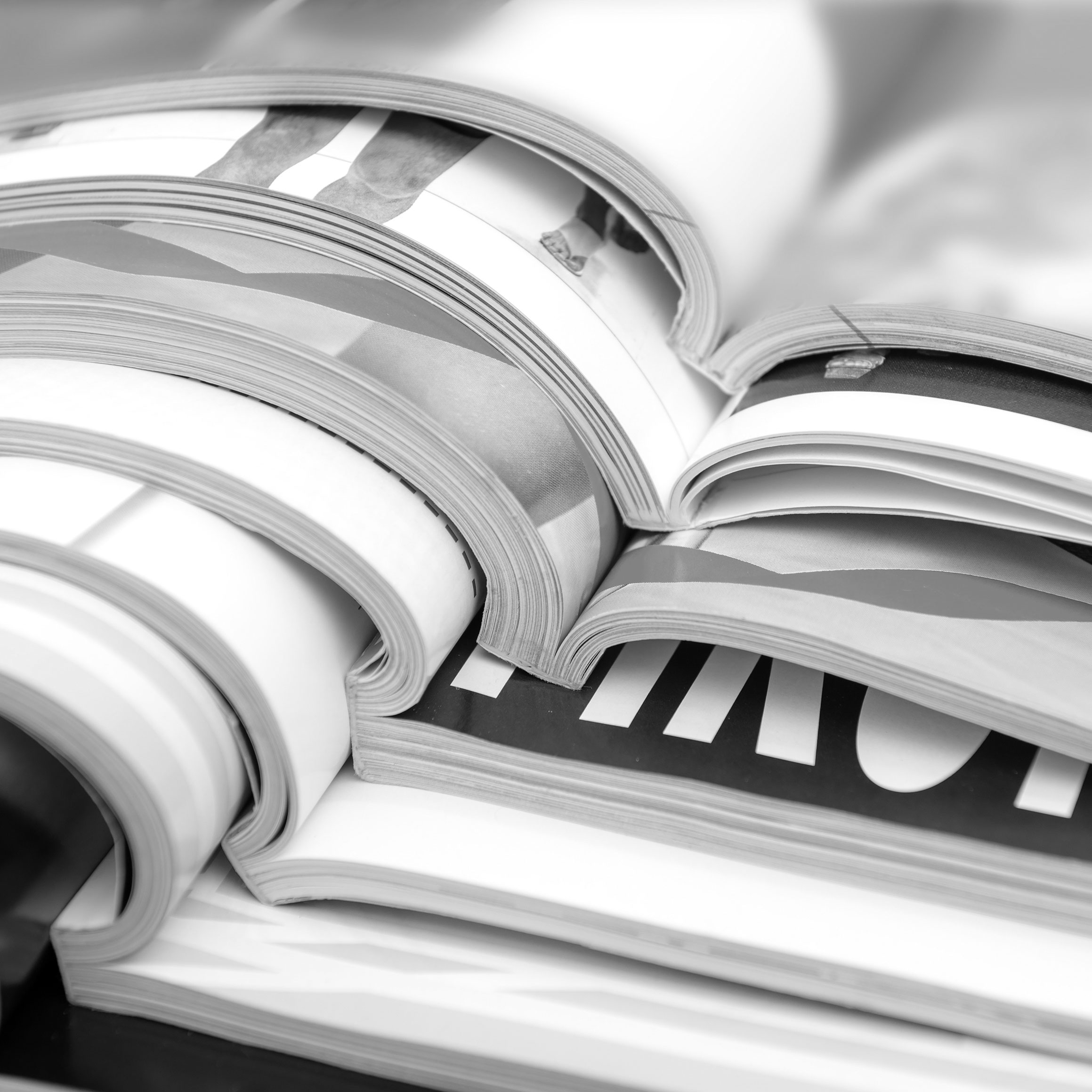 Black-and-white close-up of overlapping printed publications