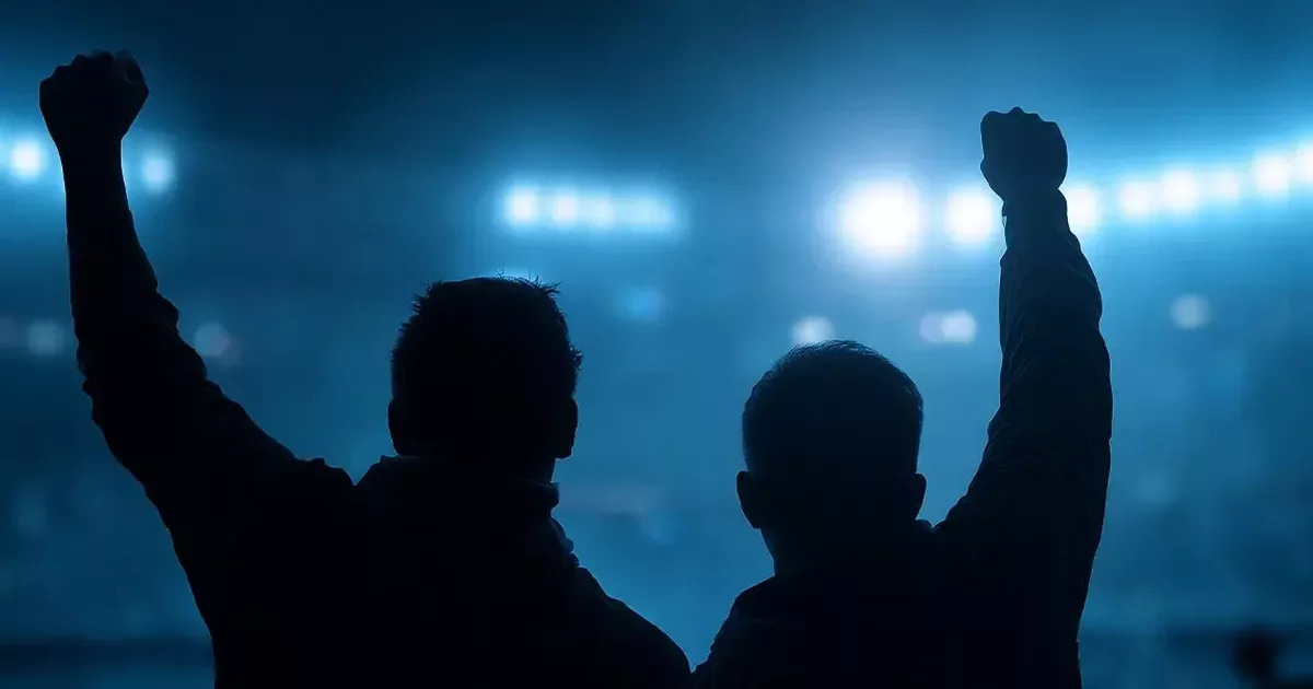 Silhouetted sports fans raising their fists under stadium lights