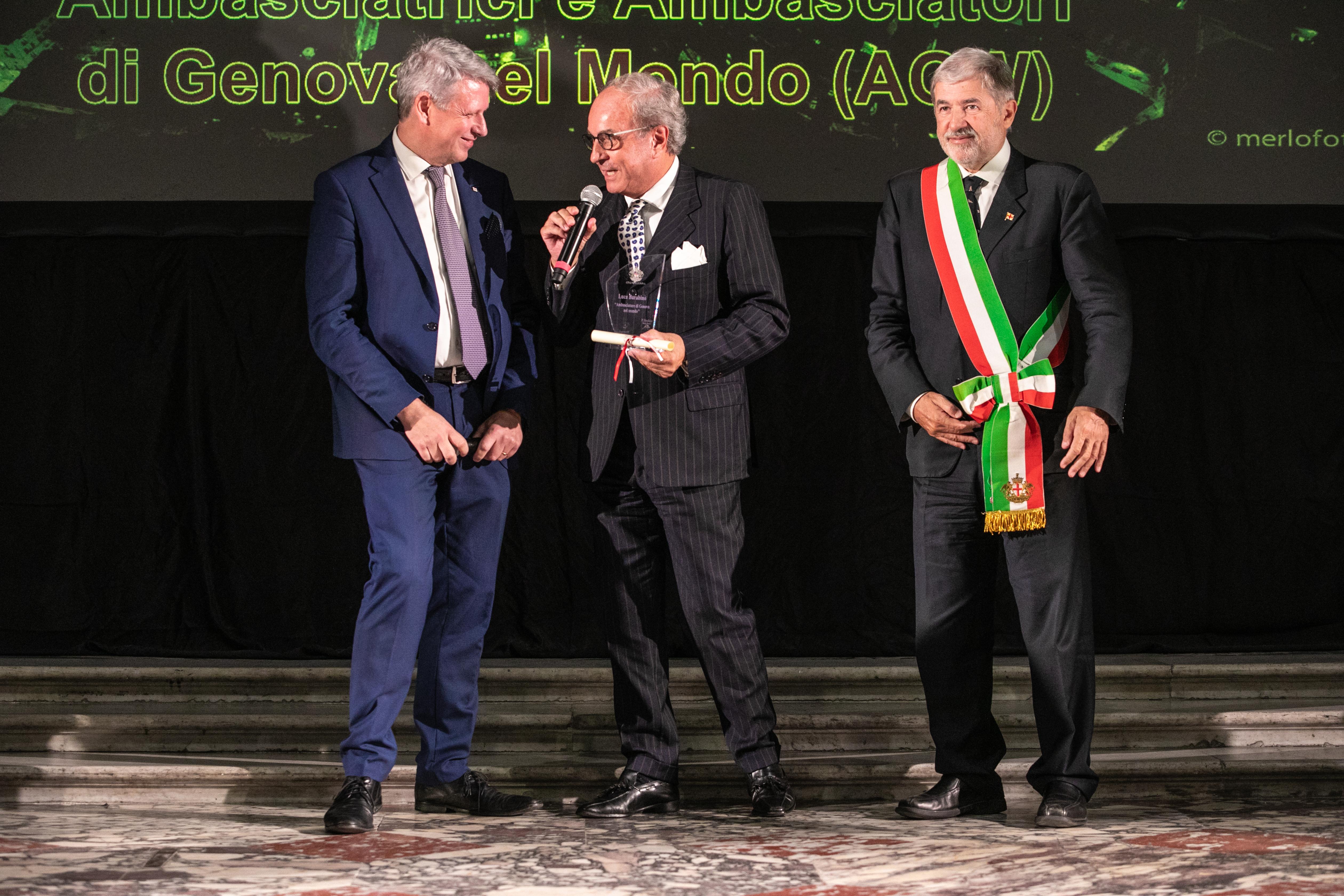Luca Barabino holding a microphone and award at Genoa’s 2023 ambassador ceremony.