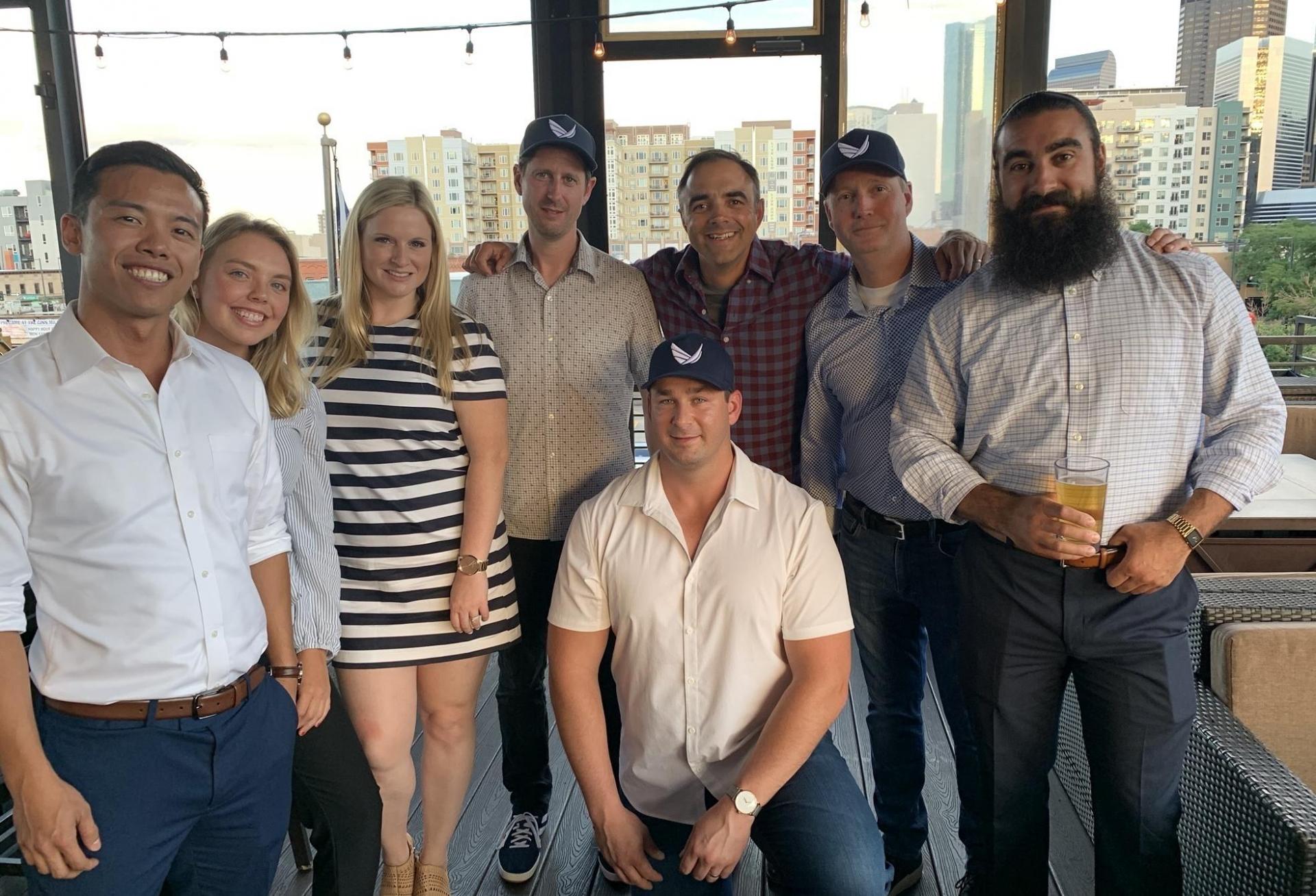 Lucas Rotter kneeling with Valcre co-founders Kris Owens and Grant Norling and members of the Valcre team