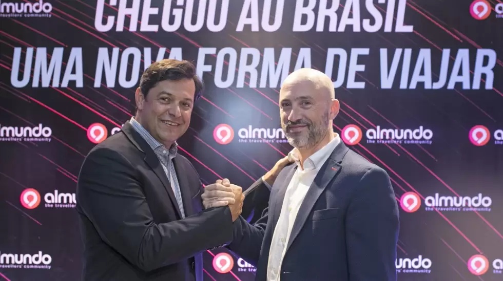 Luciano Barreto, left, with Almundo CEO Juan Pablo Lafosse in front of an Almundo Brazil backdrop