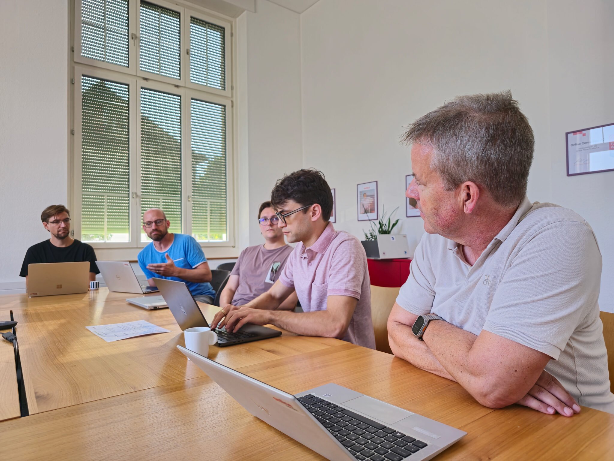 Lukas Martinelli and Online Group colleagues seated around a conference table during an AI workshop in Switzerland