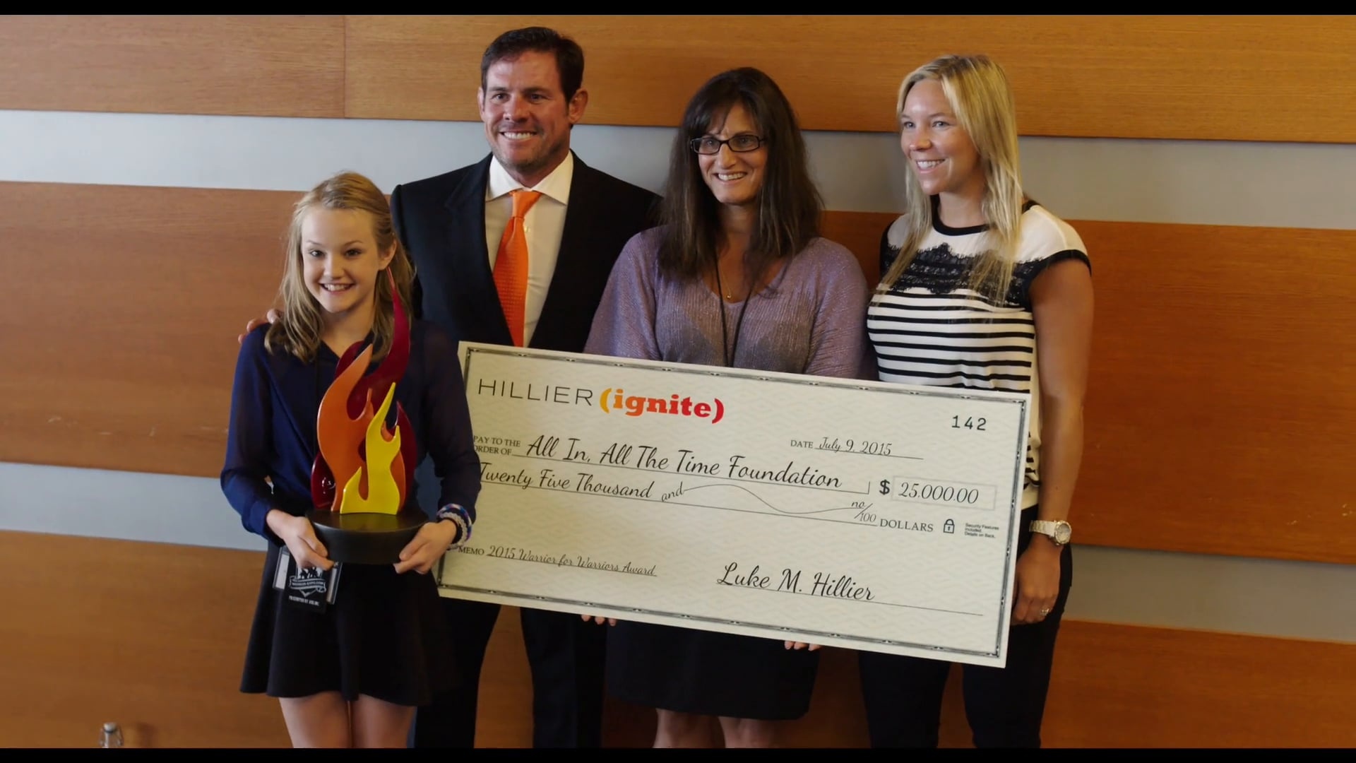 Luke Hillier stands with an award recipient group holding a $25,000 Hillier Ignite cheque for the All In, All The Time Foundation.