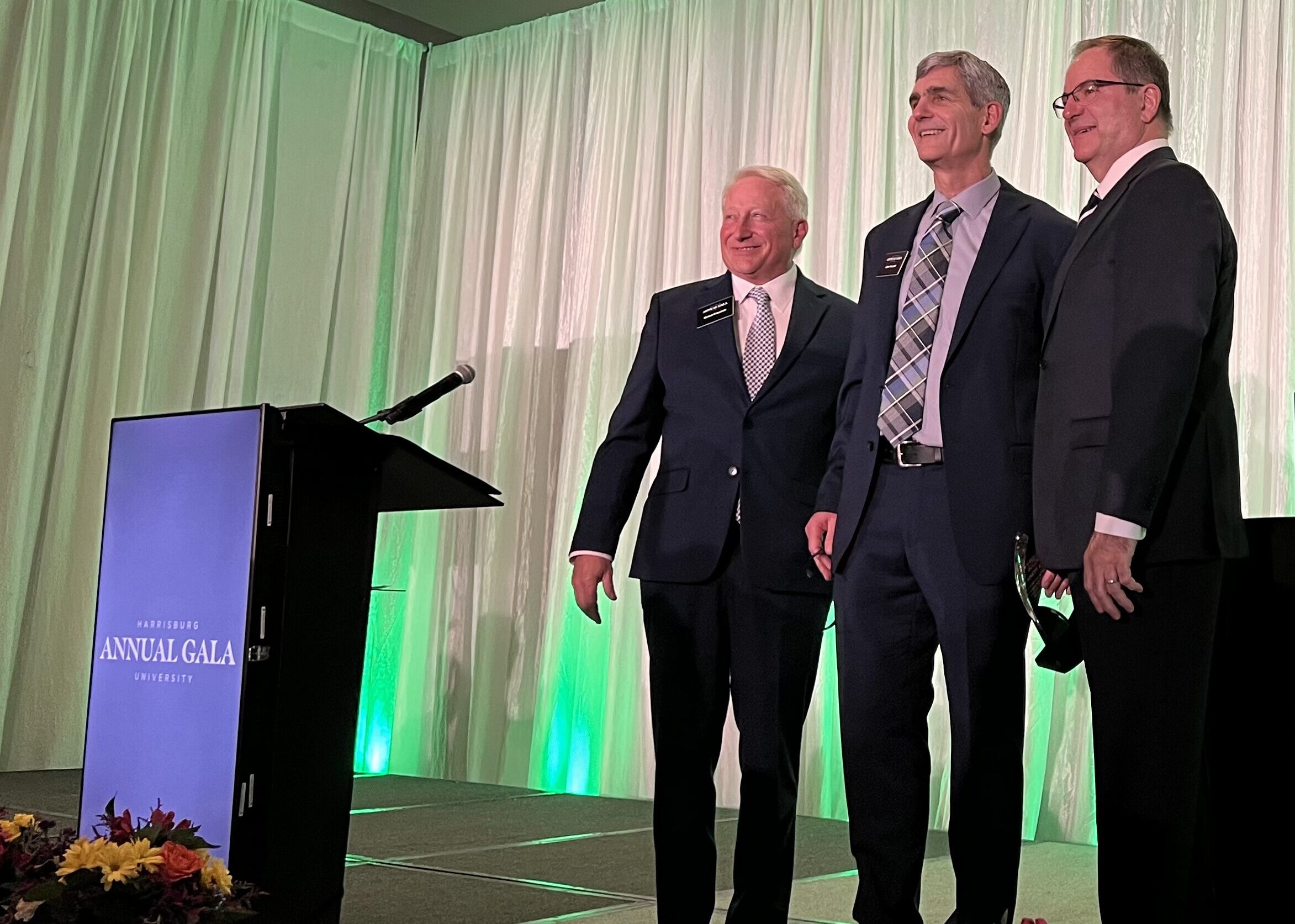 Luke Kempski accepts the Harrisburg University Corporate Impact Award between Michael Fiaschetti and David Schankweiler