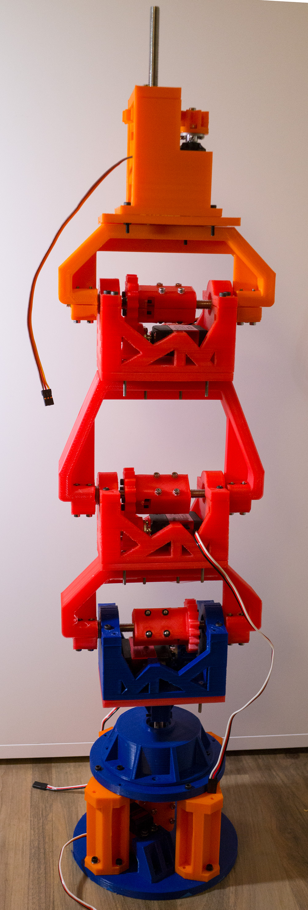 Luke Metz's colorful, 3D-printed robotic arm standing upright