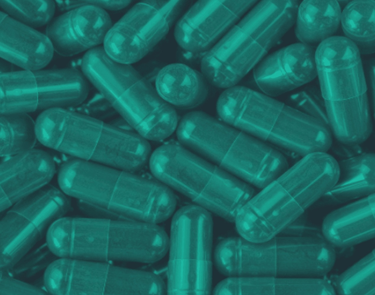 A close view of teal-tinted capsules representing Lumen's oral biologics