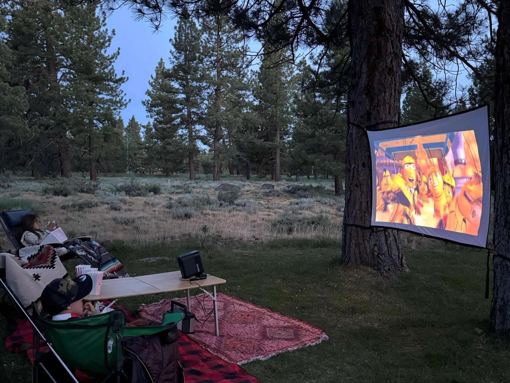 A Lumi projector lighting up a backyard movie night