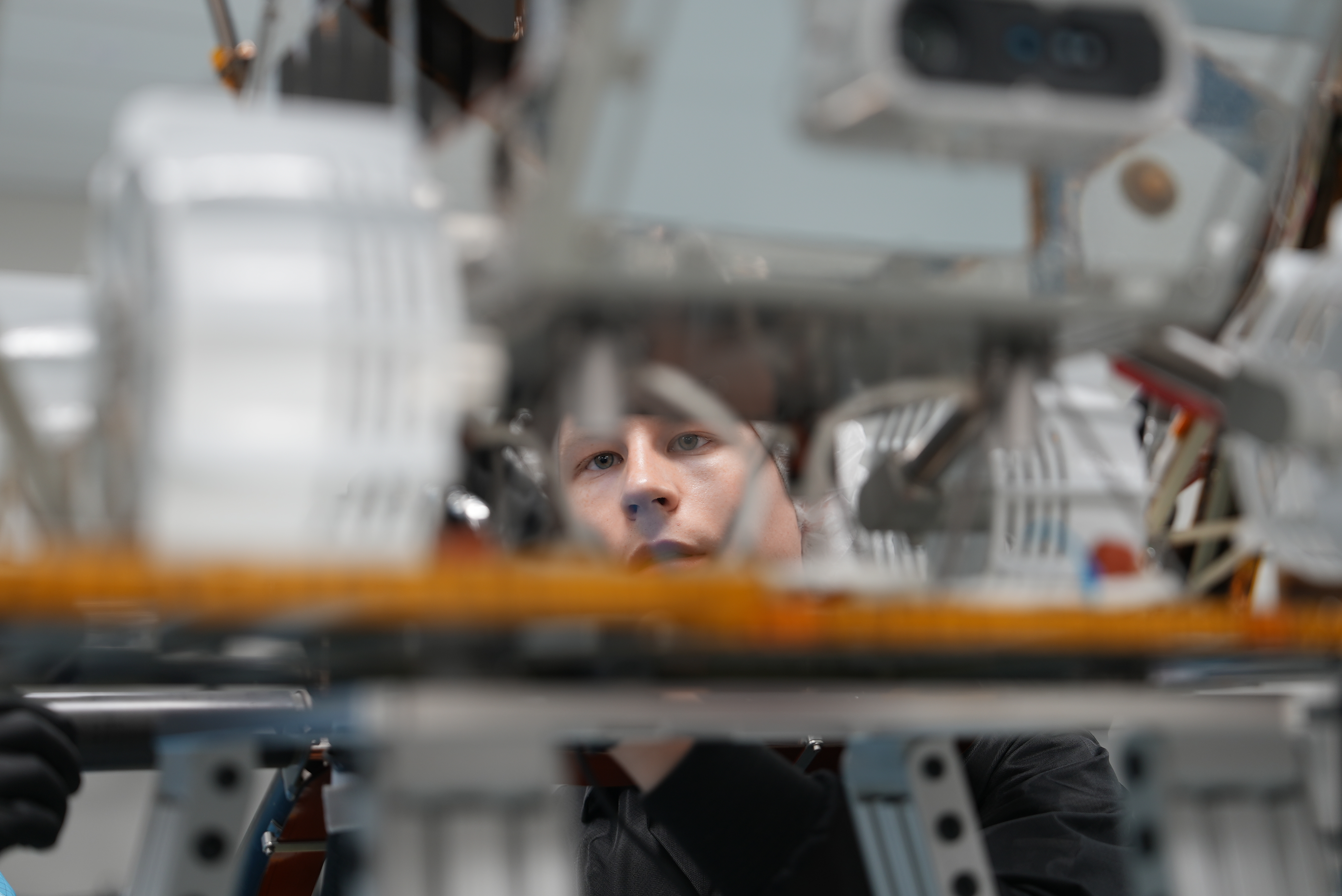 A Lunar Outpost engineer concentrating through the structure of a rover