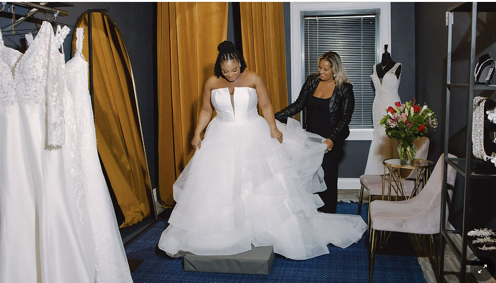 Lundyn Carter helping a bride adjust the skirt of a wedding gown inside Laine London