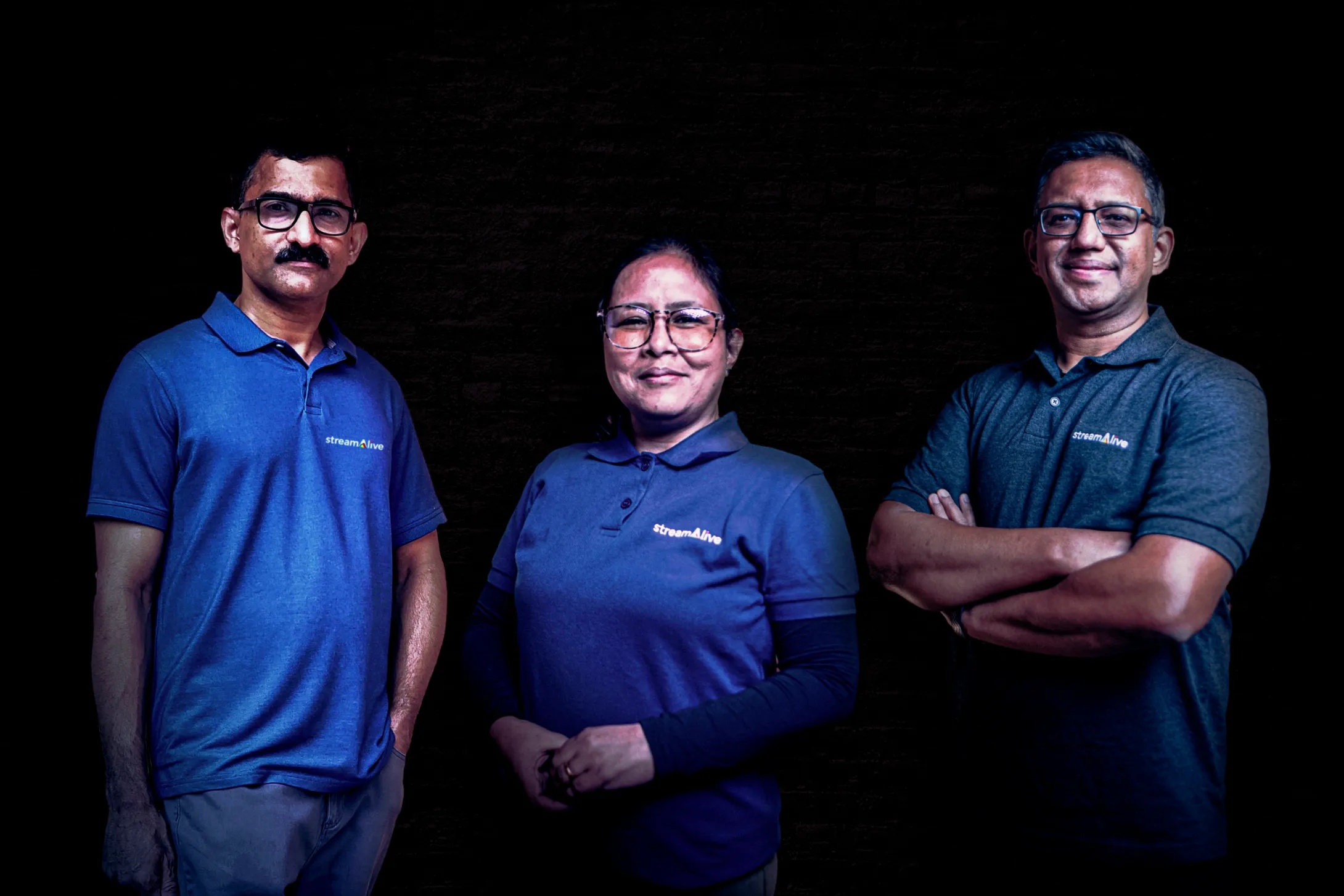 StreamAlive co-founders Joseph Varghese, Lakyntina Lyngdoh and Lux Narayan wearing matching blue company shirts