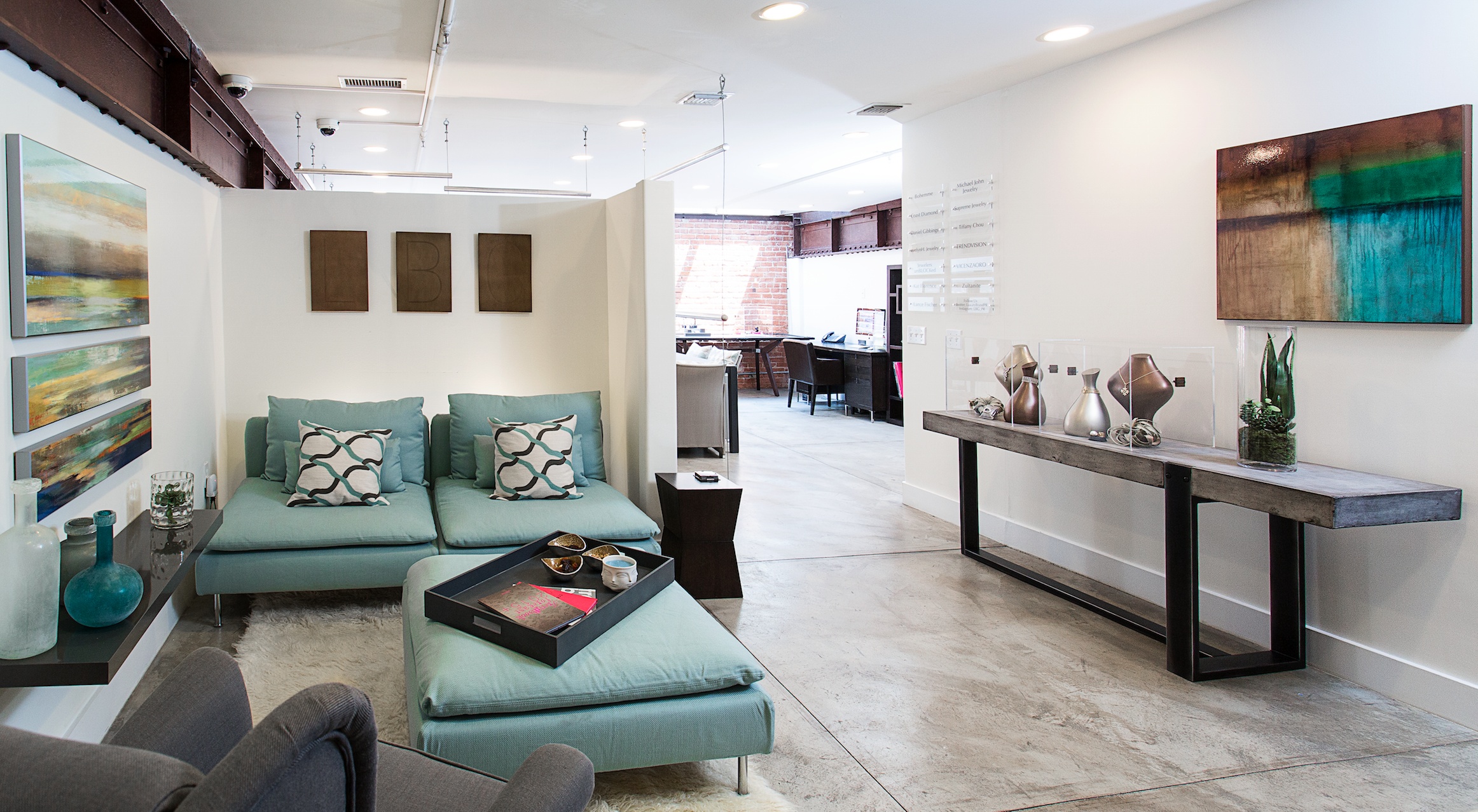 Luxury Brand Group’s Los Angeles showroom with jewelry displays, turquoise seating and an open loft interior