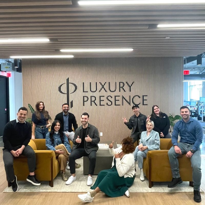 Luxury Presence colleagues gathered around yellow sofas in their office