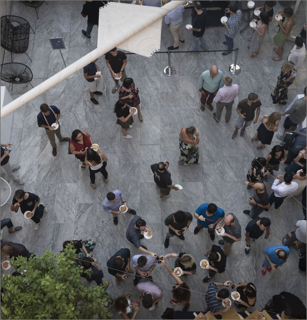 People talking in small groups around a staircase in an LVenture Group community photograph