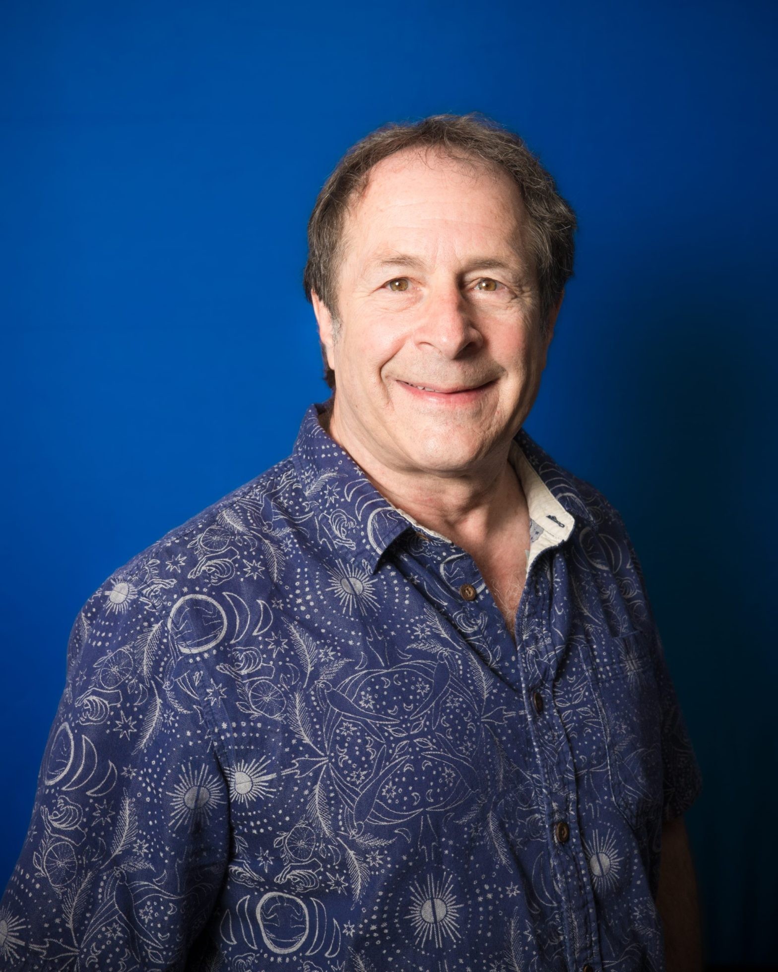 Rick Doblin, founder of MAPS, photographed against a blue backdrop