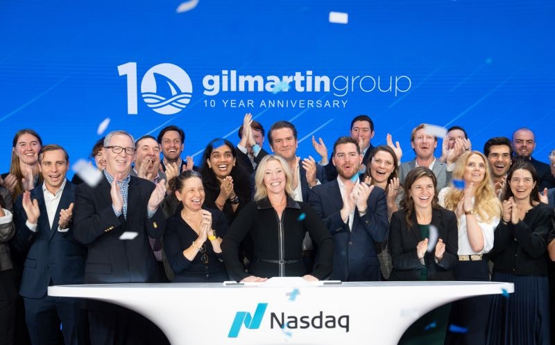 Lynn Pieper Lewis and Gilmartin colleagues celebrating their tenth anniversary at the Nasdaq bell podium