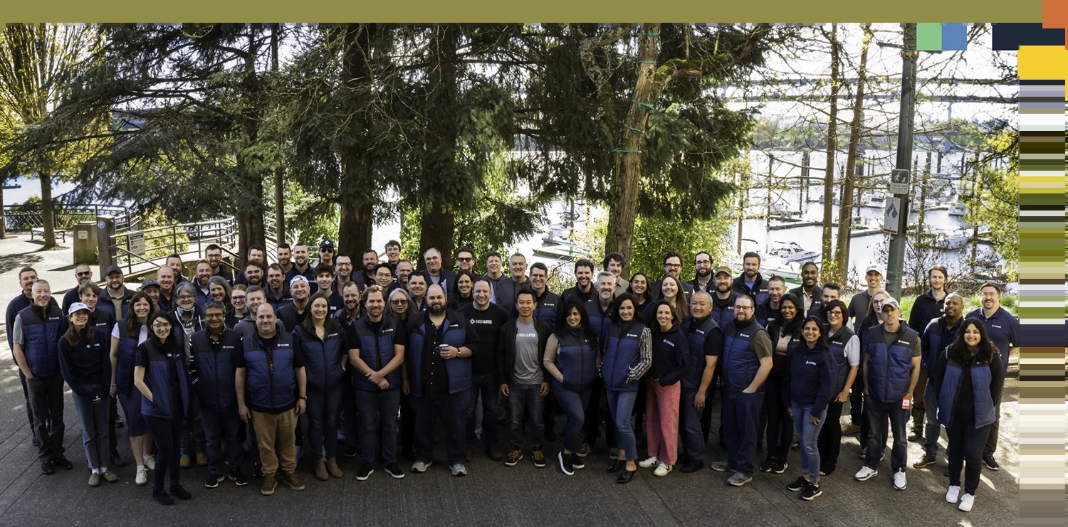 HiddenLayer team gathered outdoors beside trees and a marina