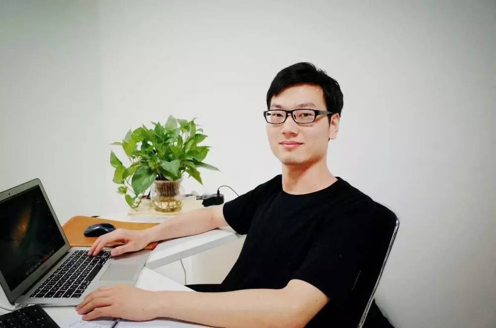 Ma Yanfei seated at a desk with a laptop and a potted plant