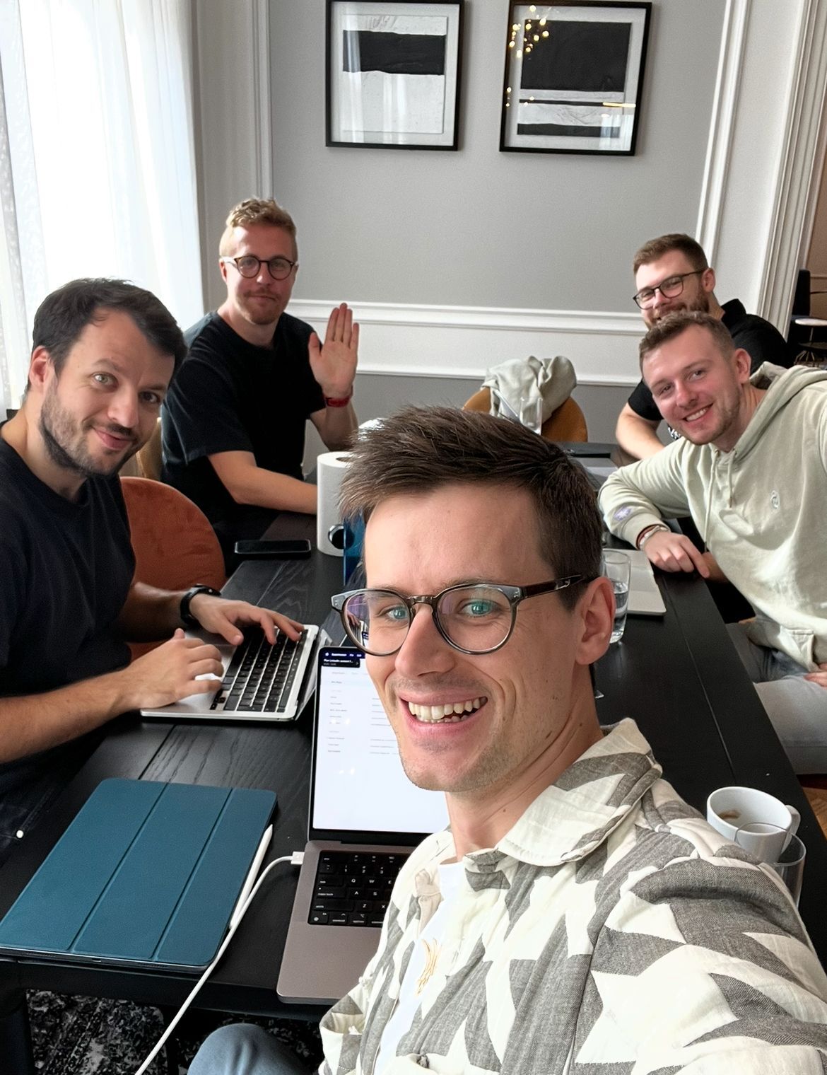 Mac Reddin taking a group photo with members of Commsor’s engineering team around a table
