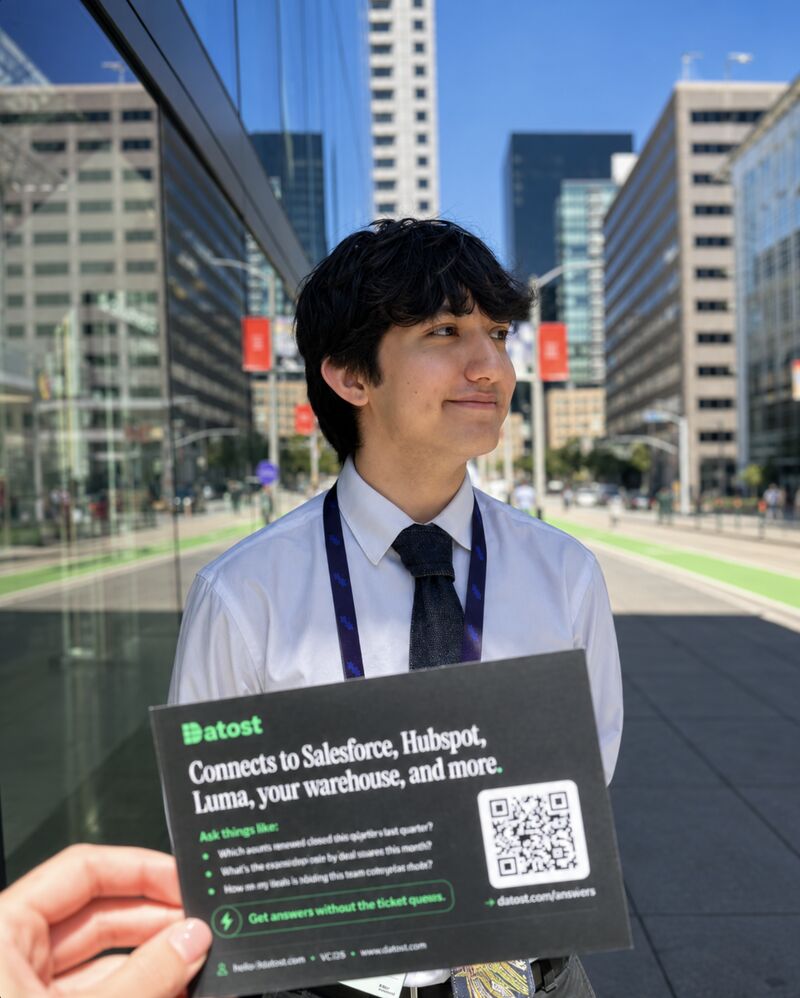 Maceo Kwik at Stripe Sessions holding a Datost card on a sunny city street