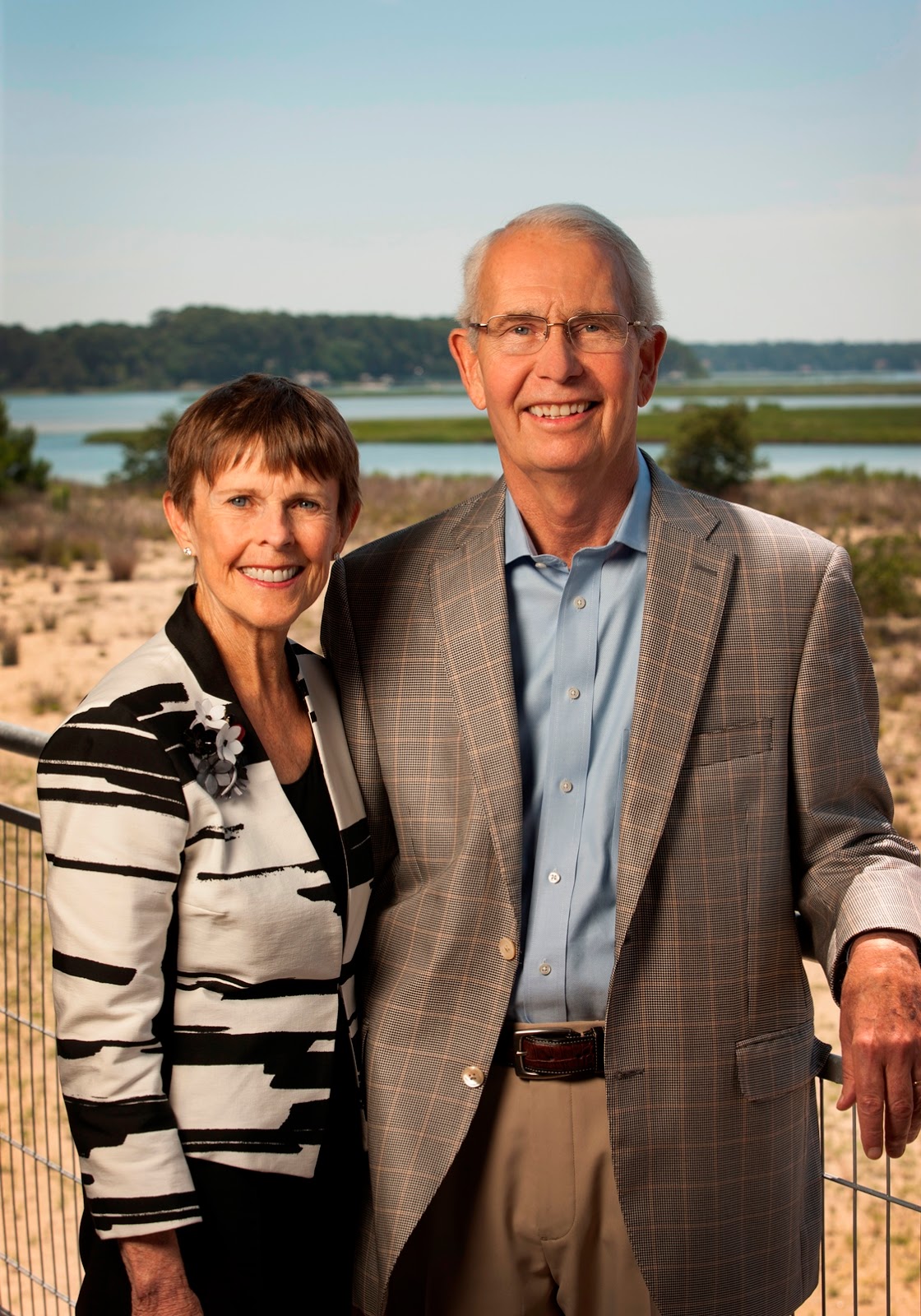 Joan and Macon Brock standing together outdoors beside the water