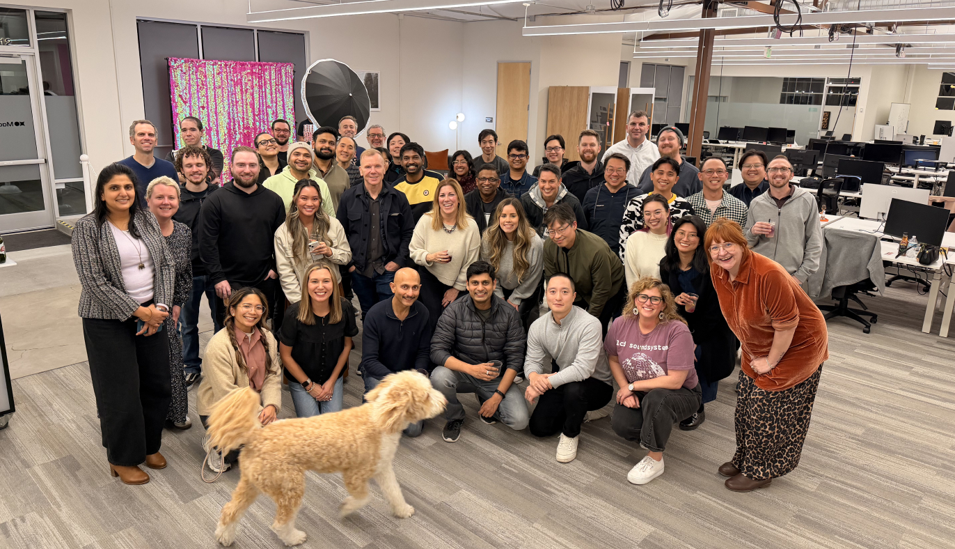 Madhive colleagues gathered in an office, with a dog walking across the foreground