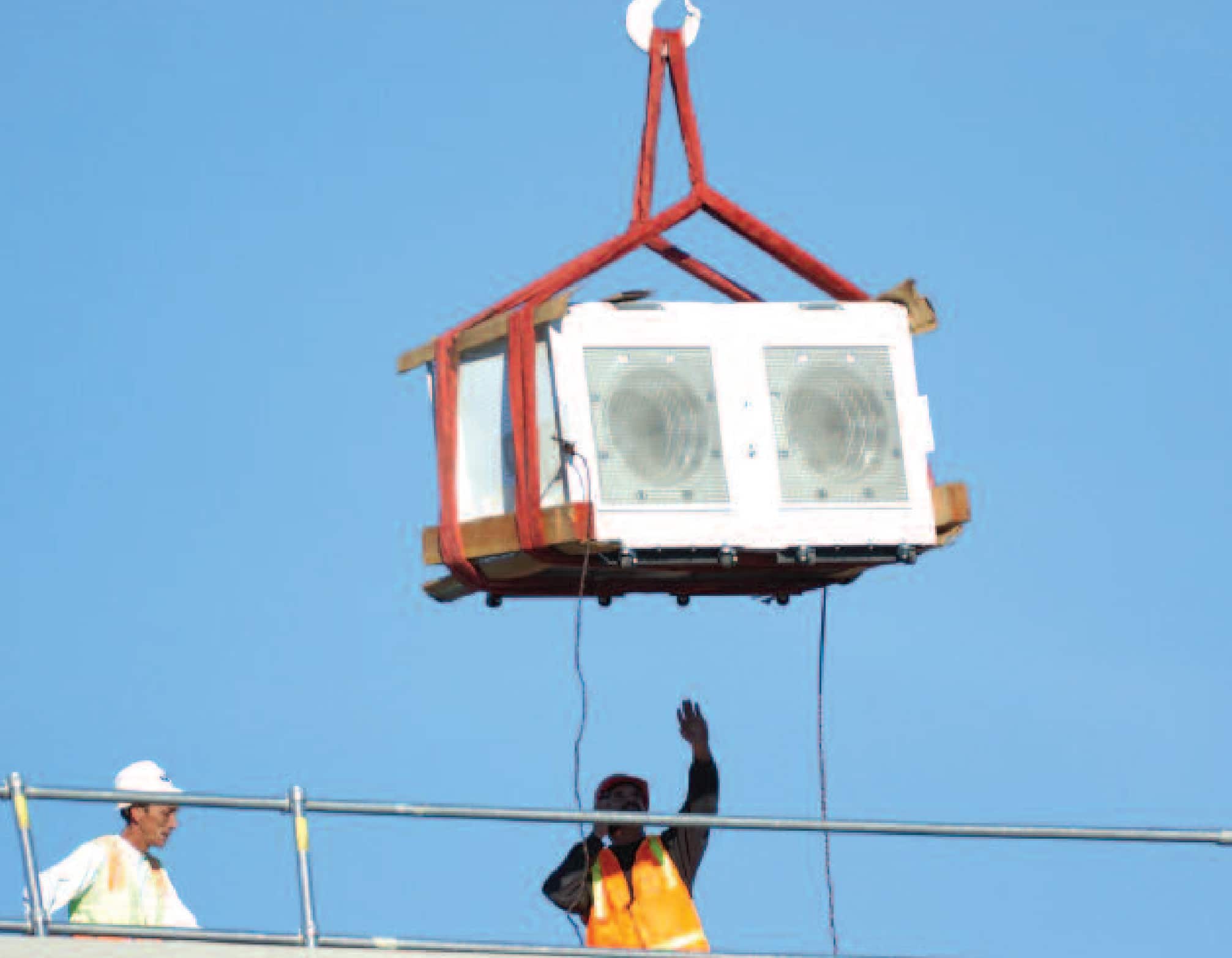 A crane lifts FANWALL modules into the hospital penthouse equipment room