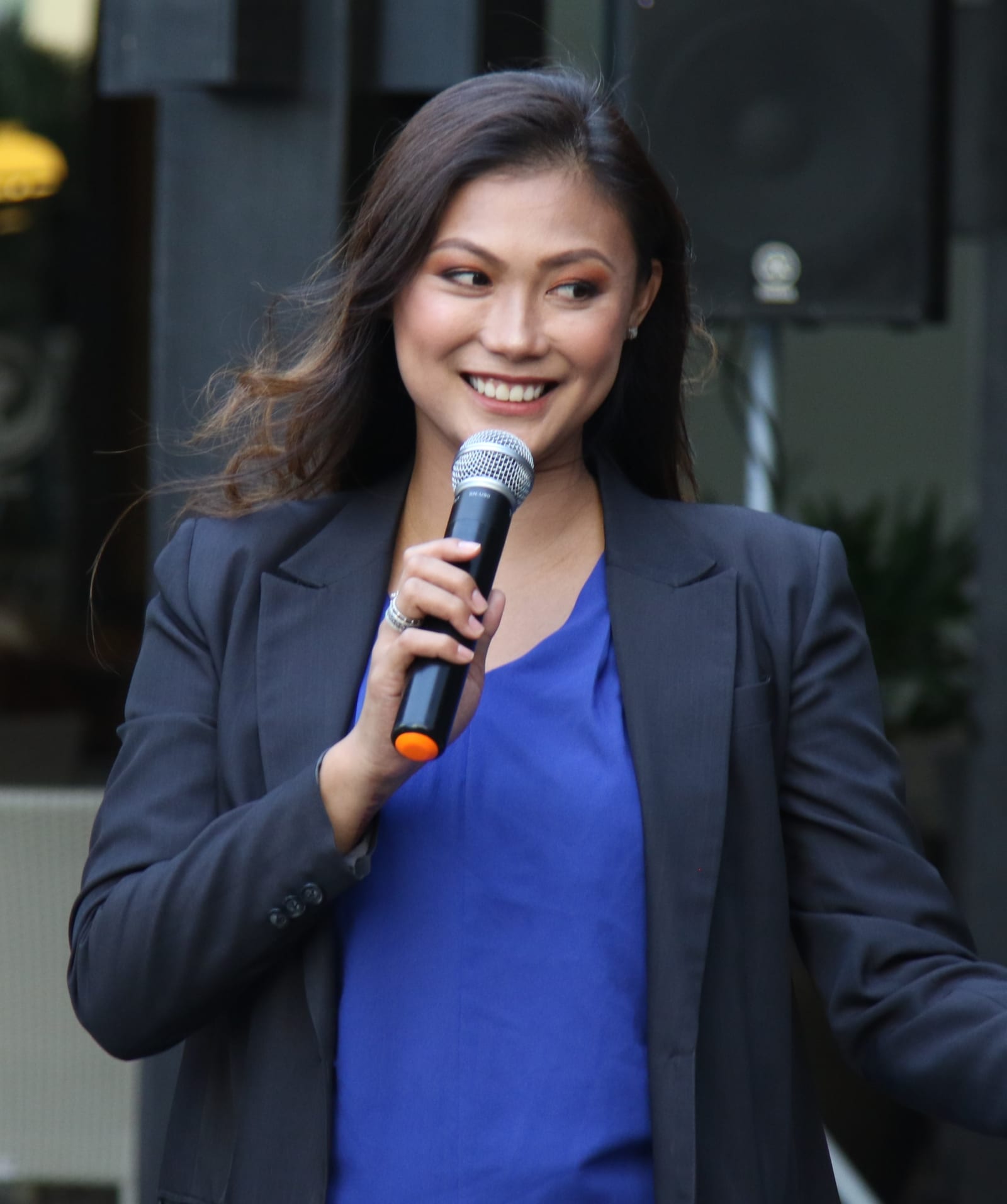 Mafae Yunon-Belasco speaking into a handheld microphone