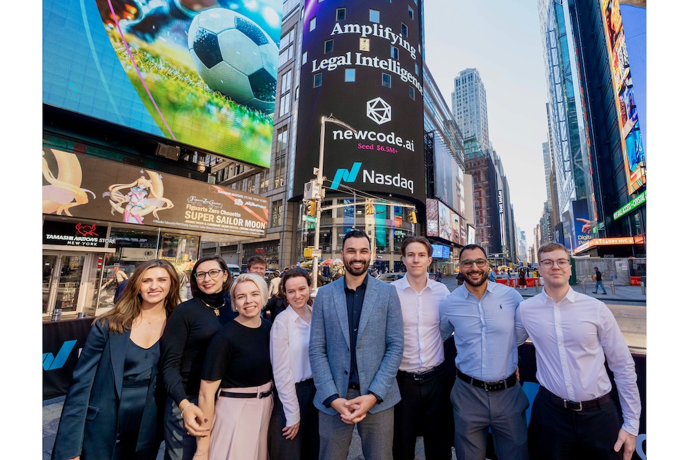 Maged Helmy at the center of the Newcode team in Times Square beneath a screen announcing the company’s seed funding