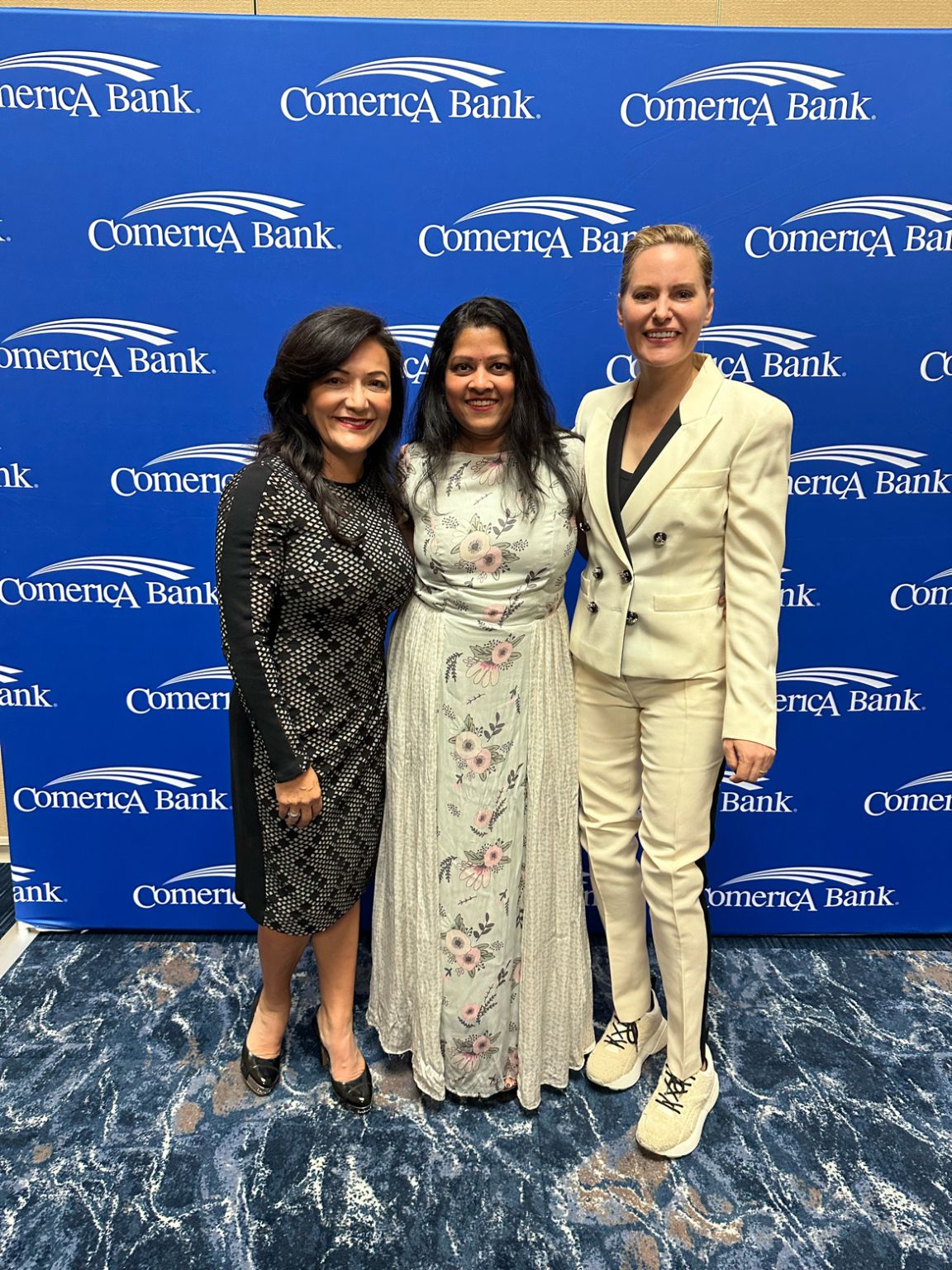 Maha Manickam at the center of a conference photograph with Nina Vaca and Aimee Mullins