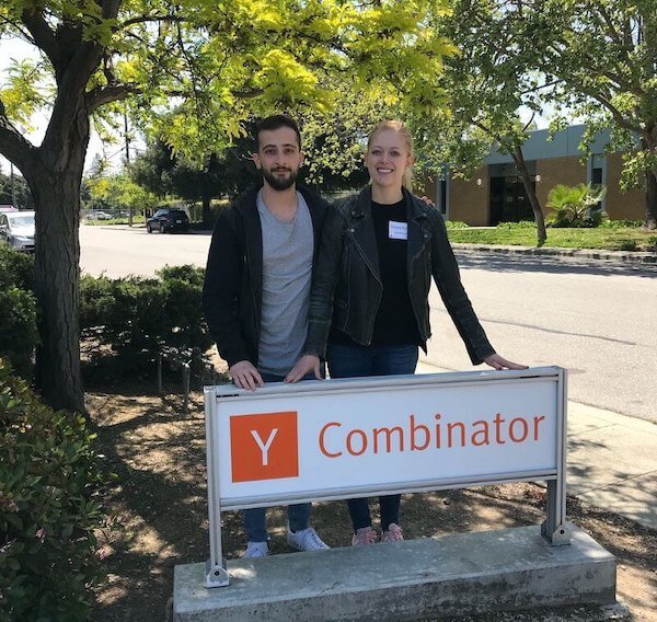 Mahyar Raissi and Daryna Kulya standing behind a Y Combinator sign