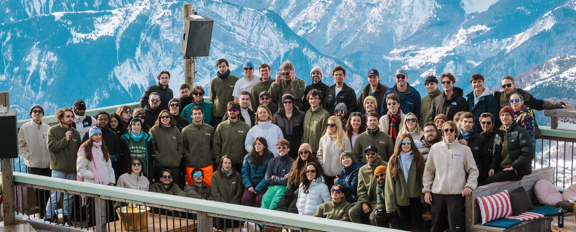 Maki team gathered outdoors in front of snowy mountains