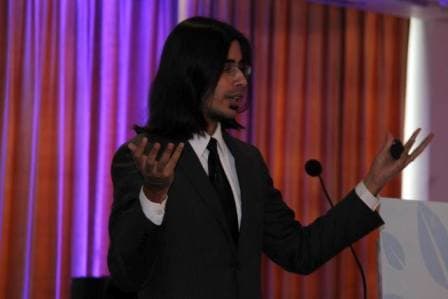 Manasij Ganguli speaking at a lectern, gesturing with both hands
