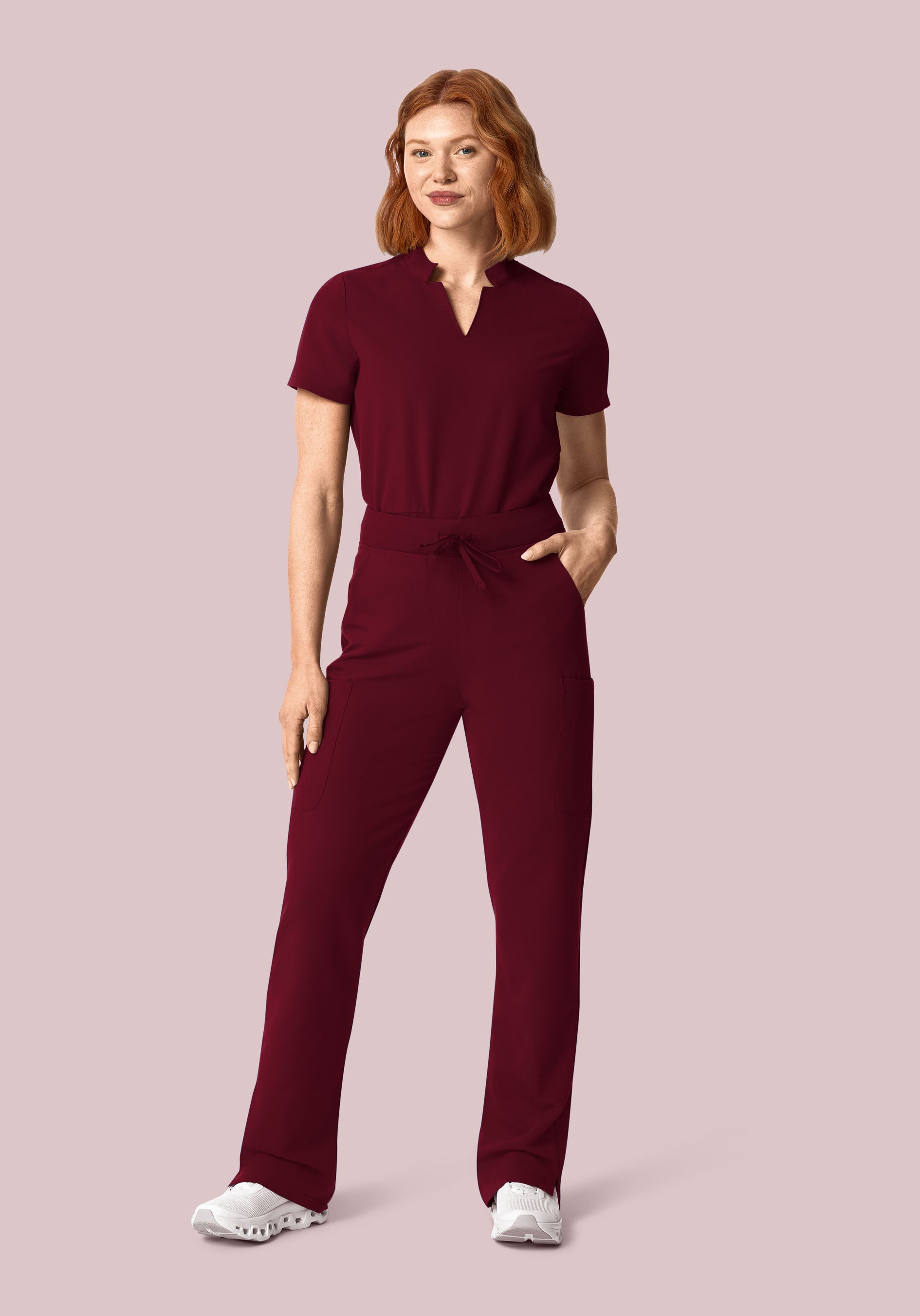 Model wearing Mandala’s wine-colored notch-neck scrub top and cargo pants