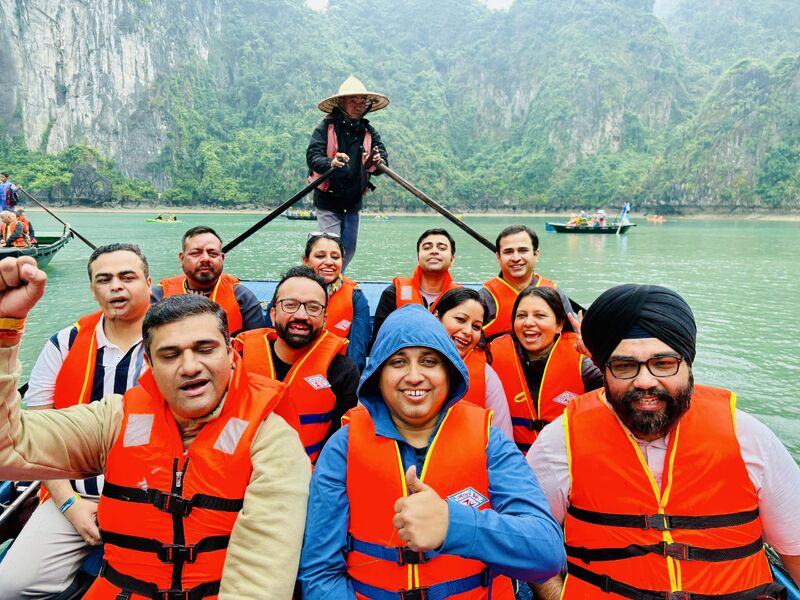 Trexo colleagues wearing orange life jackets on a boat during the Vietnam offsite