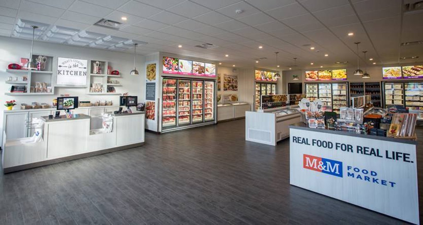 A renovated M&M Food Market interior with open aisles, visible freezers and a service counter