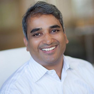 Maneesh Joshi smiling in a white shirt