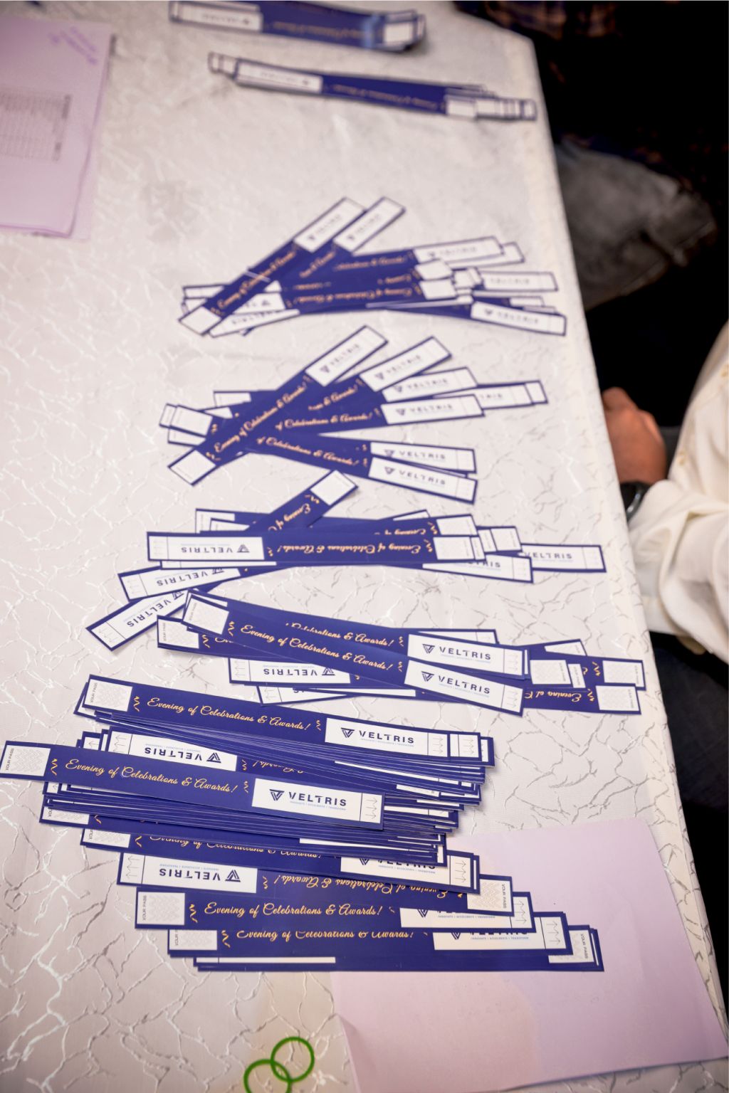 Veltris celebration wristbands spread across the welcome table