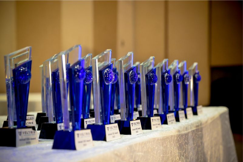 Blue Veltris Annual CEO Award trophies arranged in a row at the 2023 celebration
