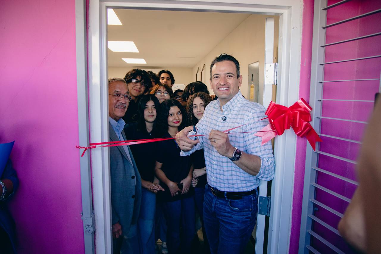 Young people gather at a ribbon-cutting at Casa de la Juventud, with Manuel Milán at left and Mayor Marco Bonilla holding scissors.