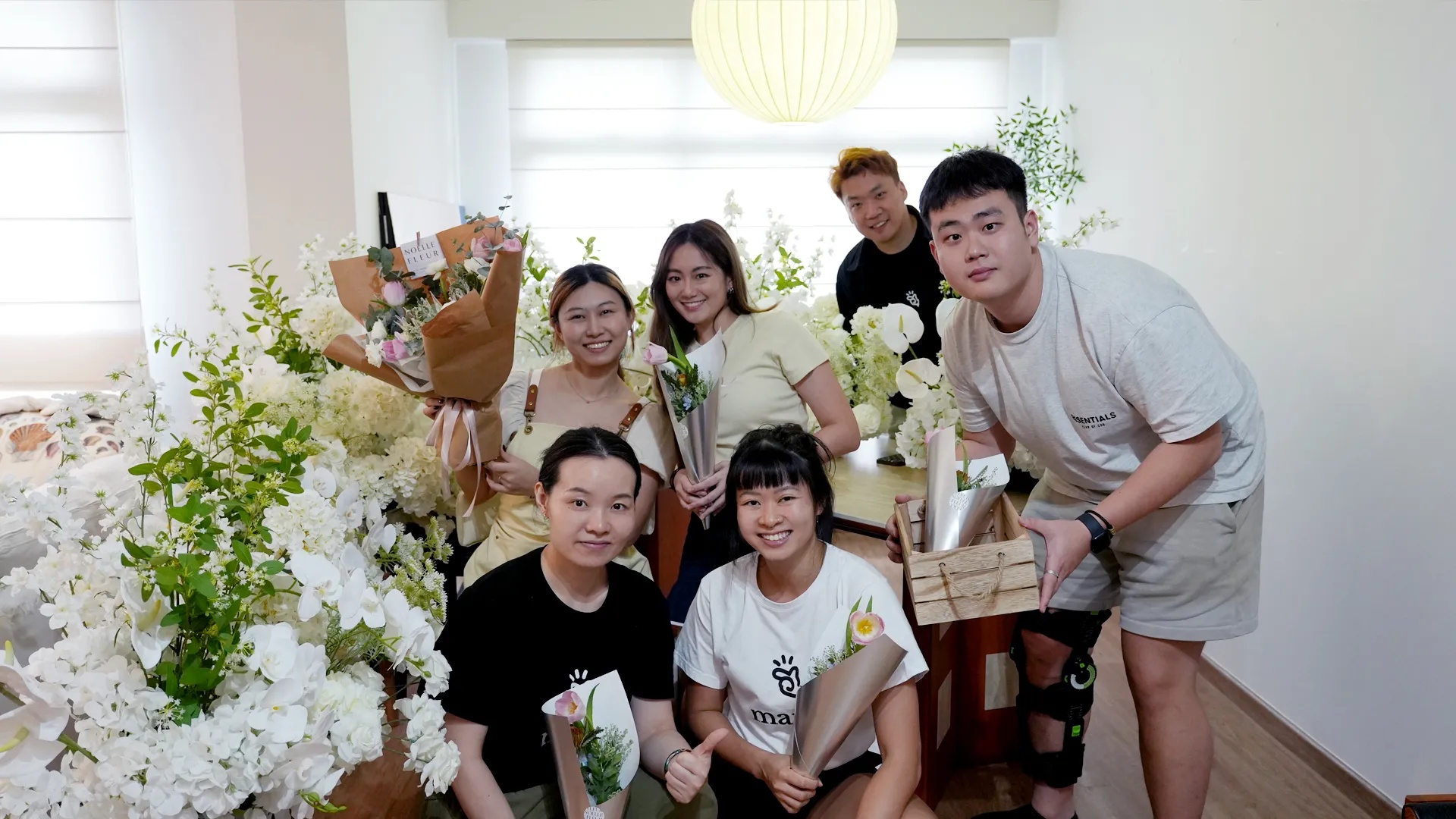 A group holding bouquets inside the flower-filled Noelle Fleur studio