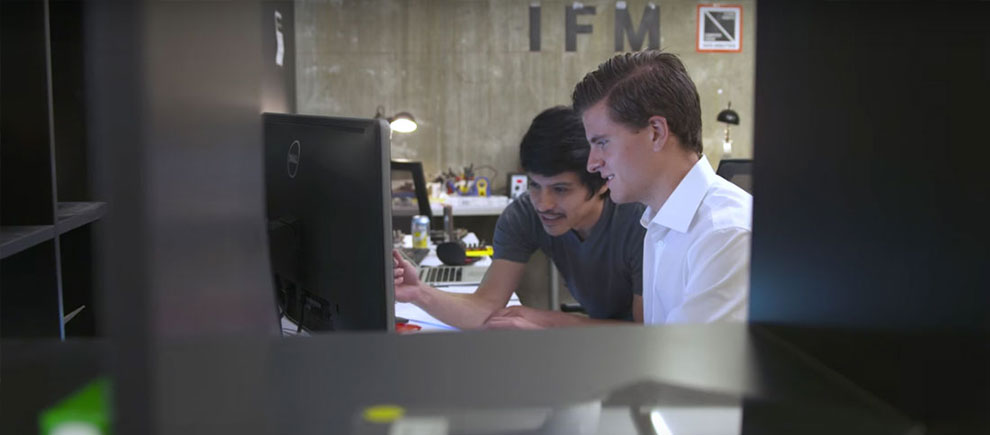 Marc Gyongyosi working at a computer with a colleague at IFM