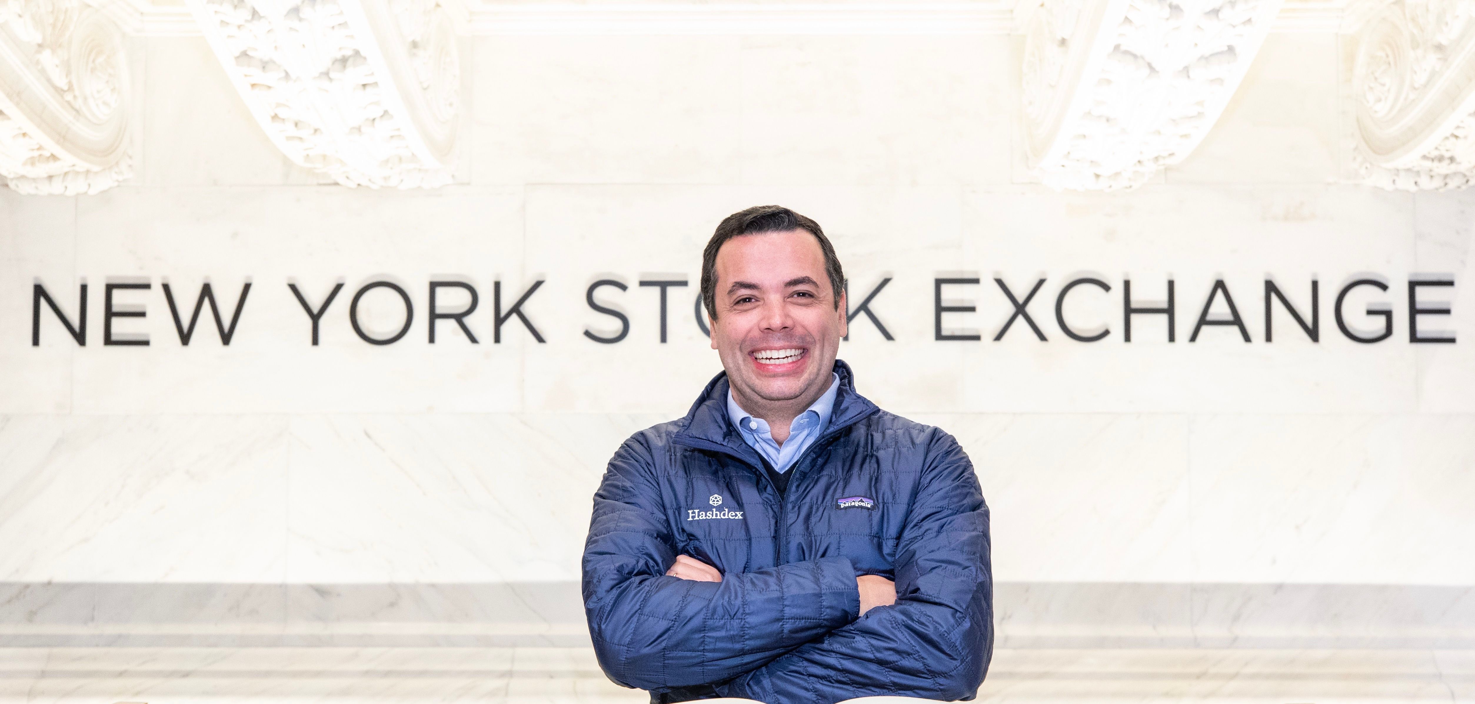 Marcelo Sampaio smiling in a Hashdex jacket beneath the New York Stock Exchange lettering