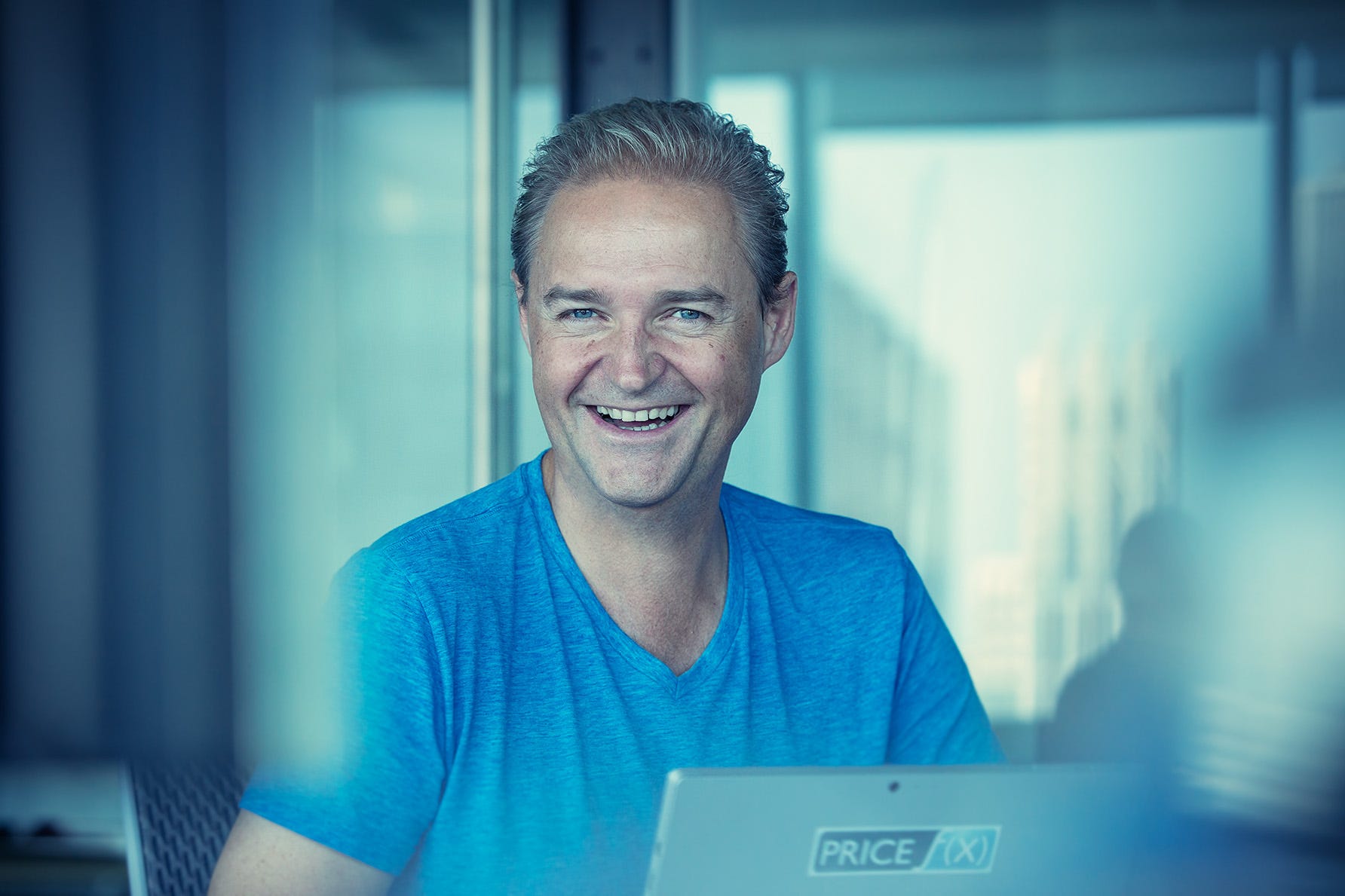 Marcin Cichon smiling behind a laptop in an office