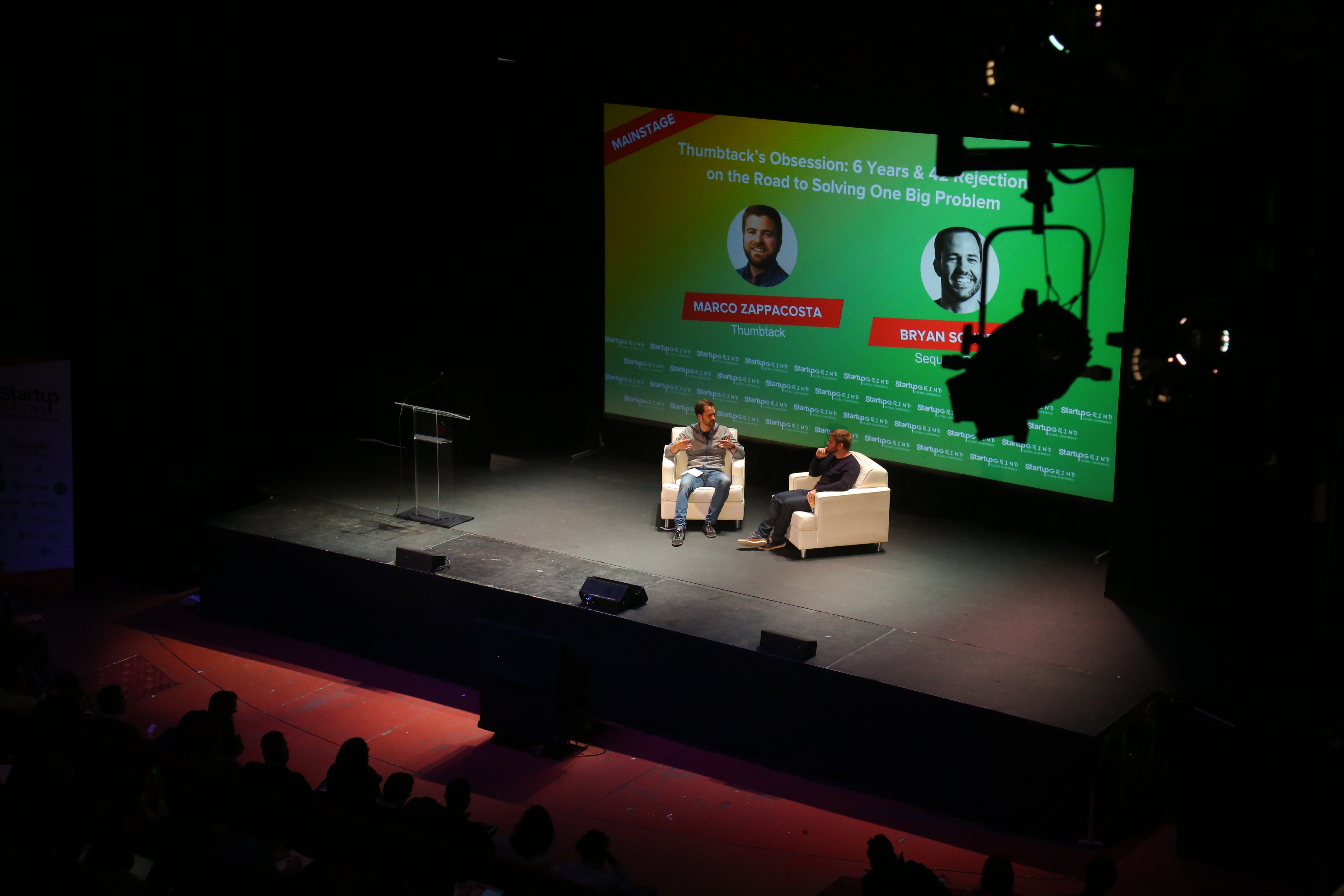 Marco Zappacosta and Bryan Schreier seated on the Startup Grind stage, with a slide about Thumbtack’s early fundraising behind them.