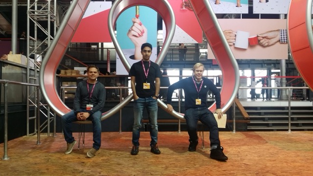 Hostaway co-founders seated and standing inside a large Airbnb symbol at an early industry gathering