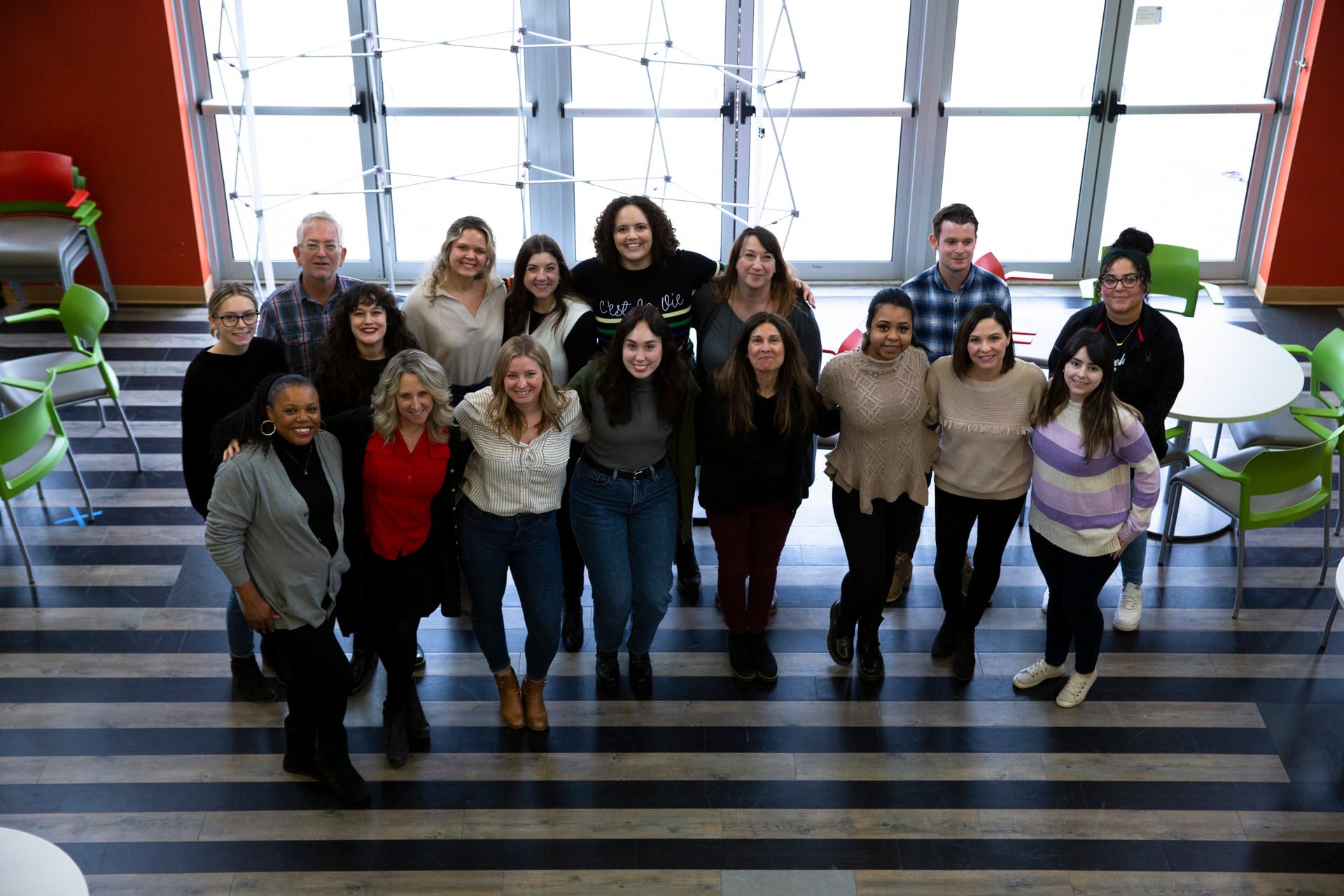 A group of Marcus Thomas employees gathered in a bright office