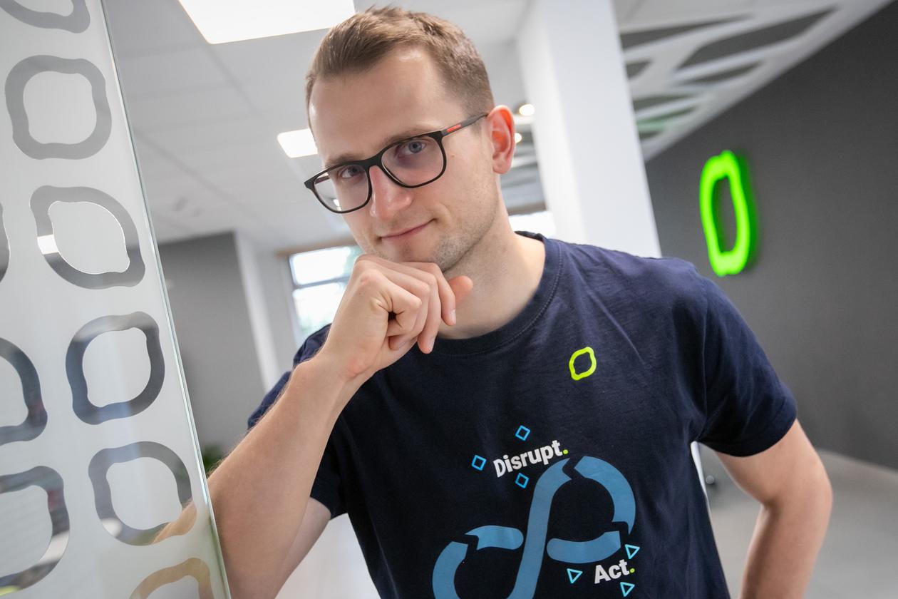 Marek Niedźwiedź in a CodiLime office, wearing a company T-shirt