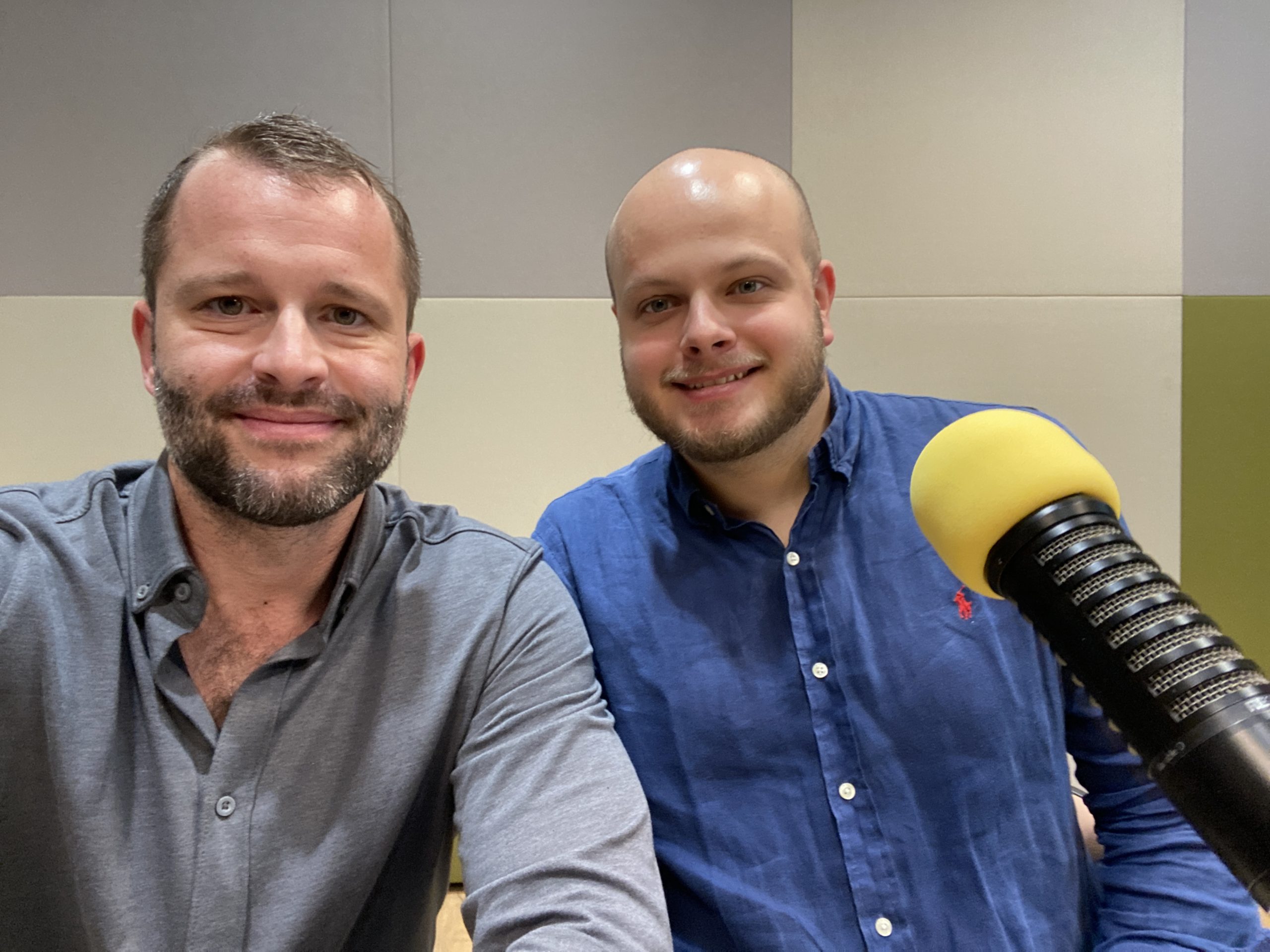 Podnicast host Peter Chodelka, left, with Marek Zamecnik, right, beside a yellow studio microphone