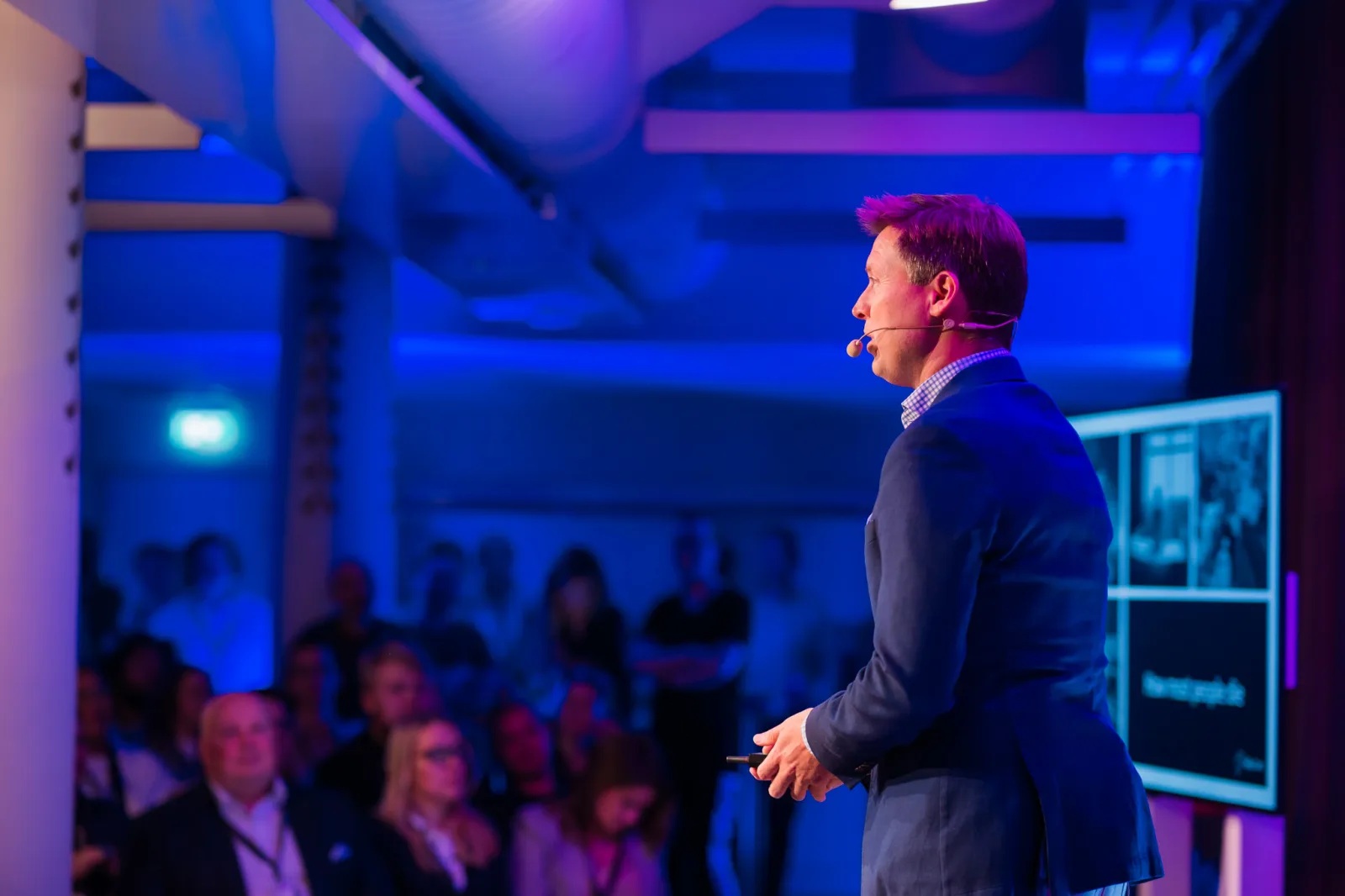 A speaker with a headset addresses an audience at a Maria 01 event