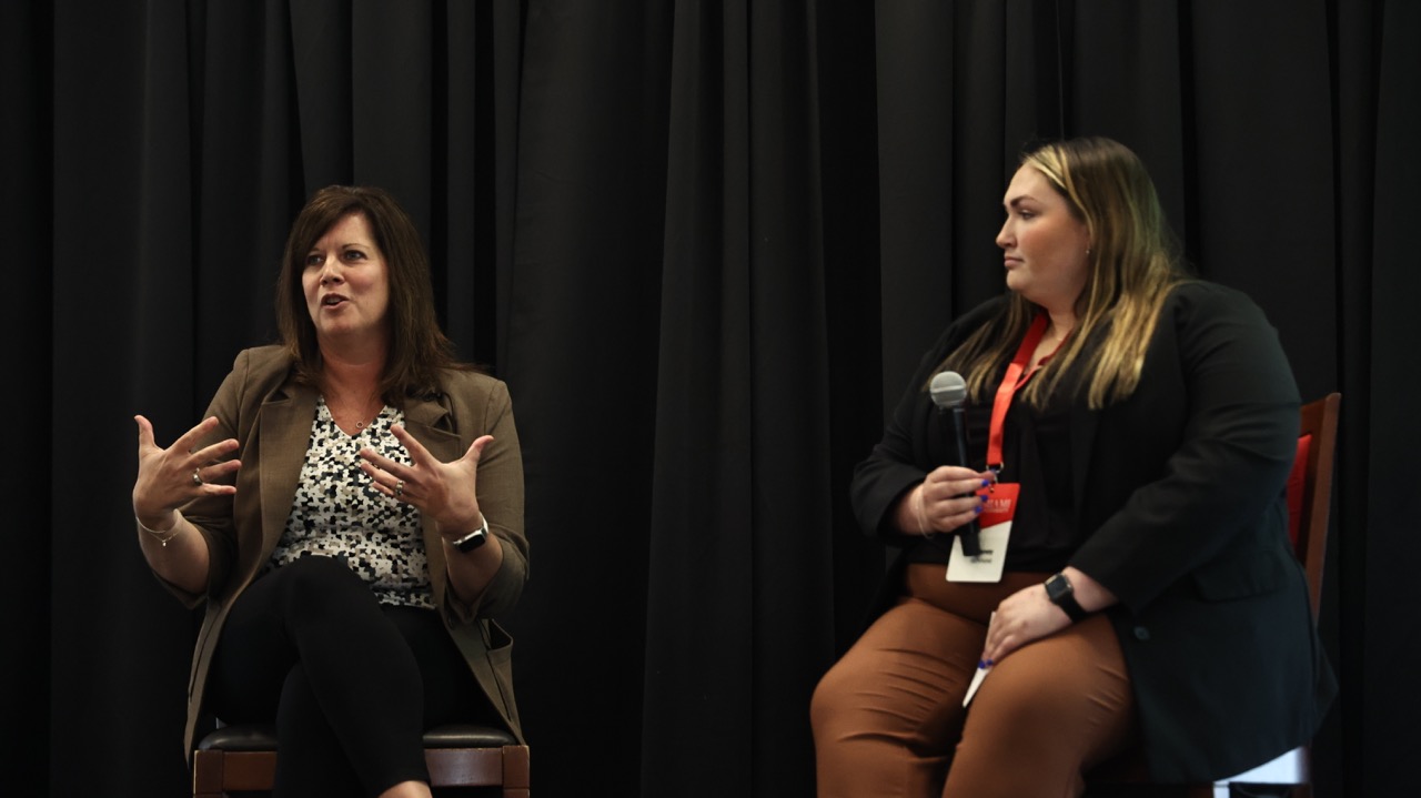 Maria Bennett answers a question beside Miami University engineering student Delaney Richmond at an alumni event